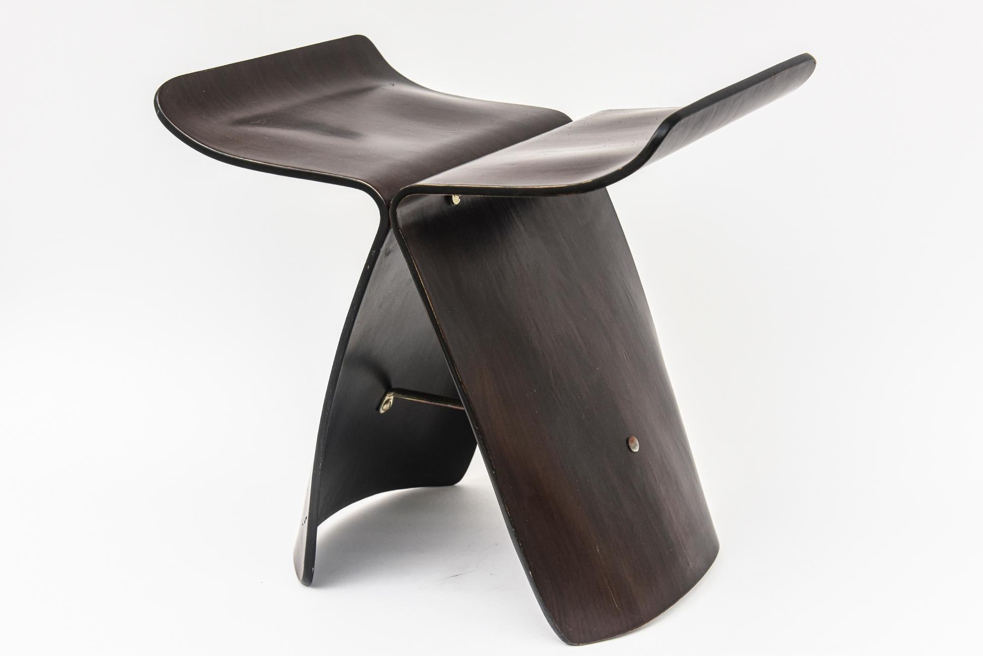 This iconic and collectable butterfly stool is a work of simple and elegant sculpture by the Japanese designer Sori Yanagi. It is rosewood and brass structure. The combination aesthetics of the yin and the yang of western function meet Asian simple