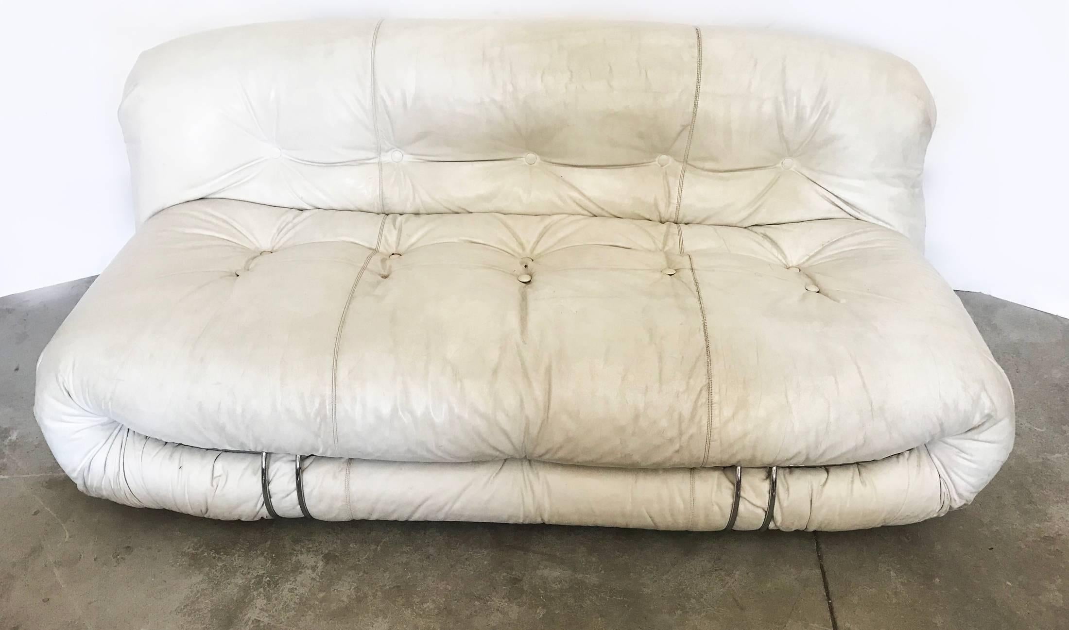 Two-seat sofa, upholstered in white leather. Designed in 1970s by Afra and Tobia Scarpa. This design is quite clever as the whole textile is one rectangle piece previously sewed and adjusted at the bottom with elastic band, seat and back with