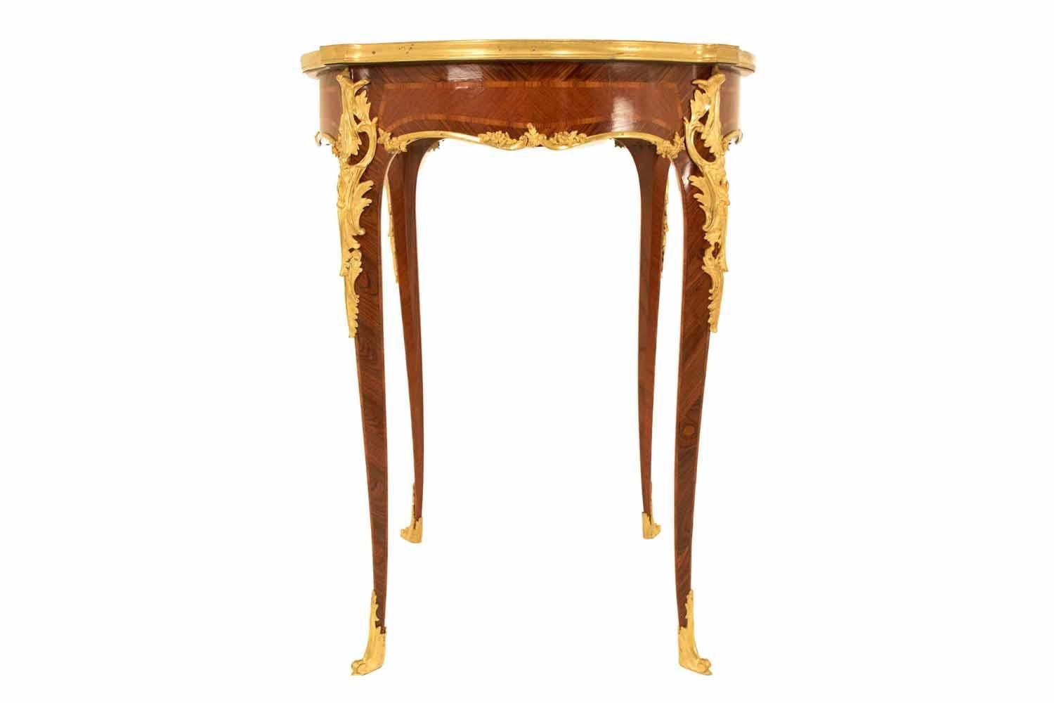Louis XV style tulipwood and kingwood marquetry pedestal table, in the manner of the Maison Sormani. It has four curved legs decorated with chiseled gilt bronzes on shoes and angles.
The curved apron is decorated by a framed marquetry and chiseled