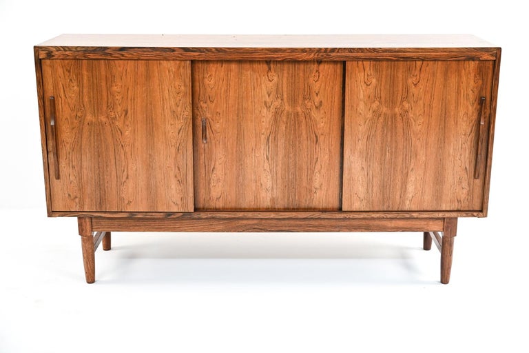 A stunning Danish mid-century tall sideboard by Soro Mobelfabrick in handsome rosewood veneer. Interior is fitted with ample shelving. On sleek tapered legs. This versatile piece would be eye-catching in a dining or living space for storage, or even