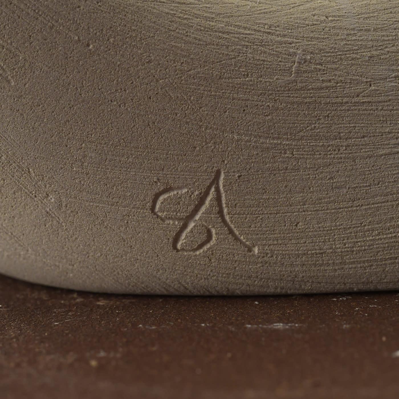 The Sorriso del Mare light sculpture features a unique organic form characterized by flowing curves and voids that create dynamic light and shadow effects. Crafted from a rare marine-origin stone found in southern Italy, the sculpture is illuminated