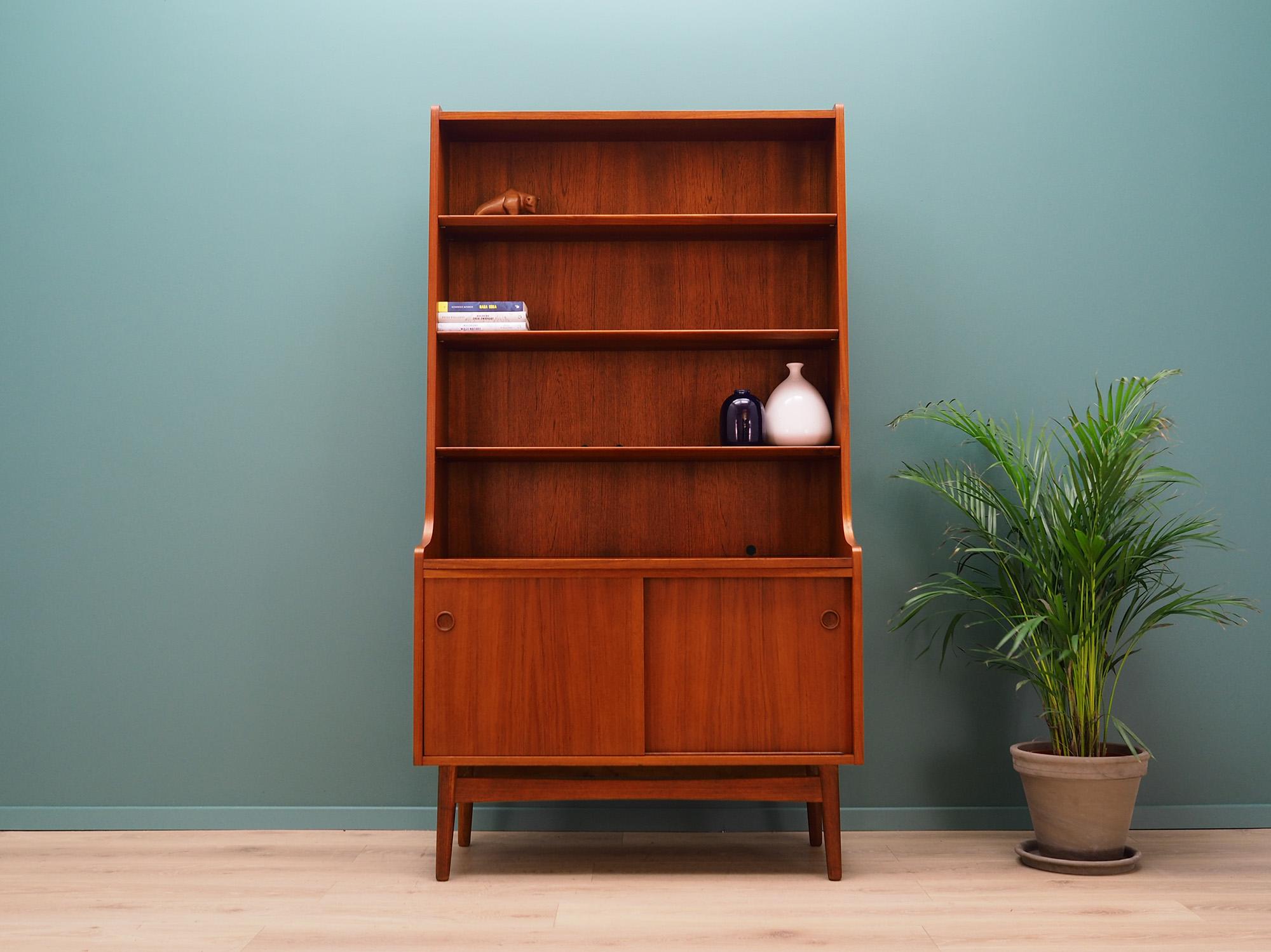 Fantastic bookcase / library from the 1960s-1970s. Danish design, Minimalist form. Designed by Johannes Sorth. Surface of the furniture finished with teak veneer. Shelves with height adjustment, shelf behind sliding door. Preserved in good condition