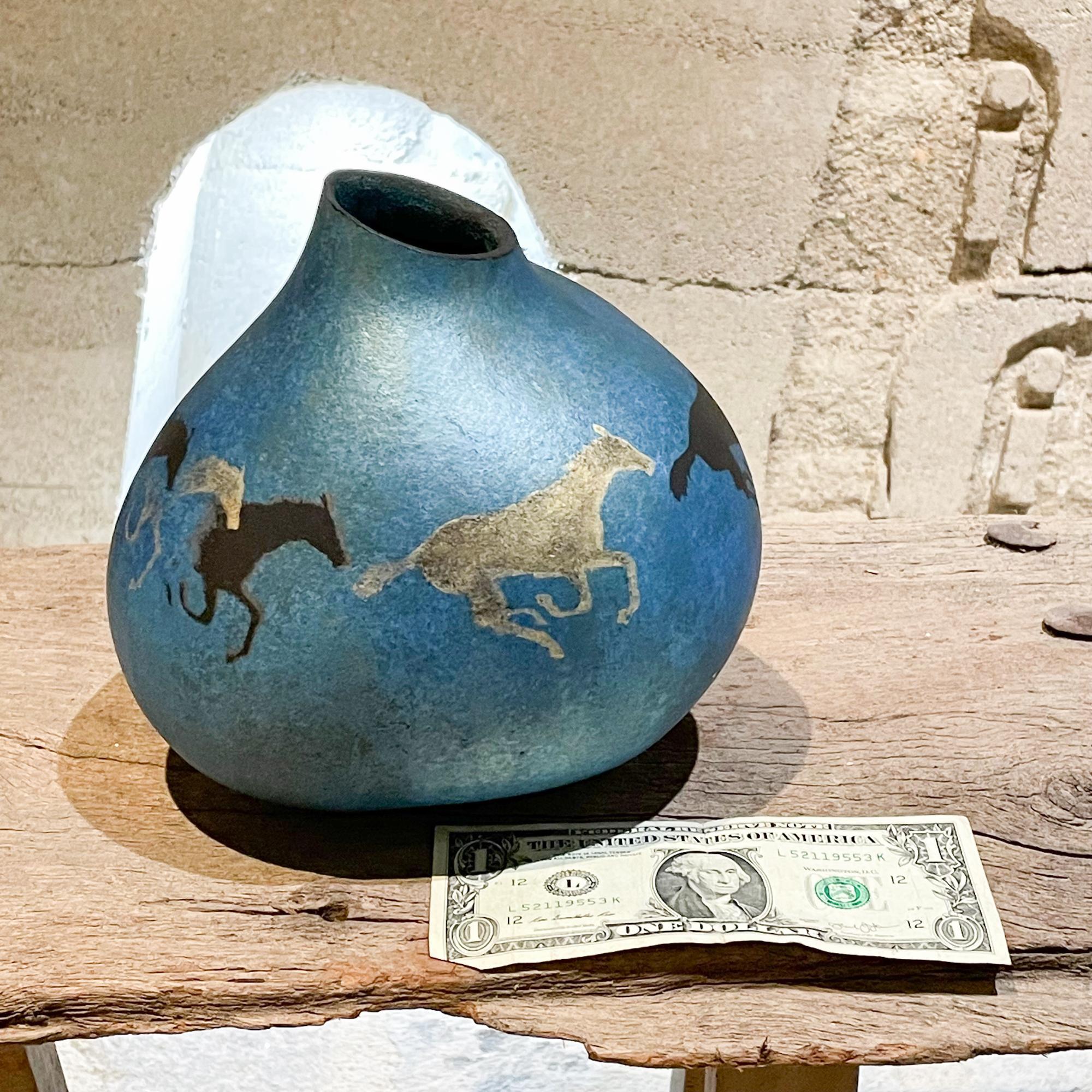 Gourd Horse Art Galloping Horses in metallic blue signed by Soszynski 
Metallic blue with the scene of horses running. Resembles cave paintings at Altamira, Spain. 
Measures: 7.75tall x 7diameter inches
Signed on bottom SOSZYNSKI
Unrestored