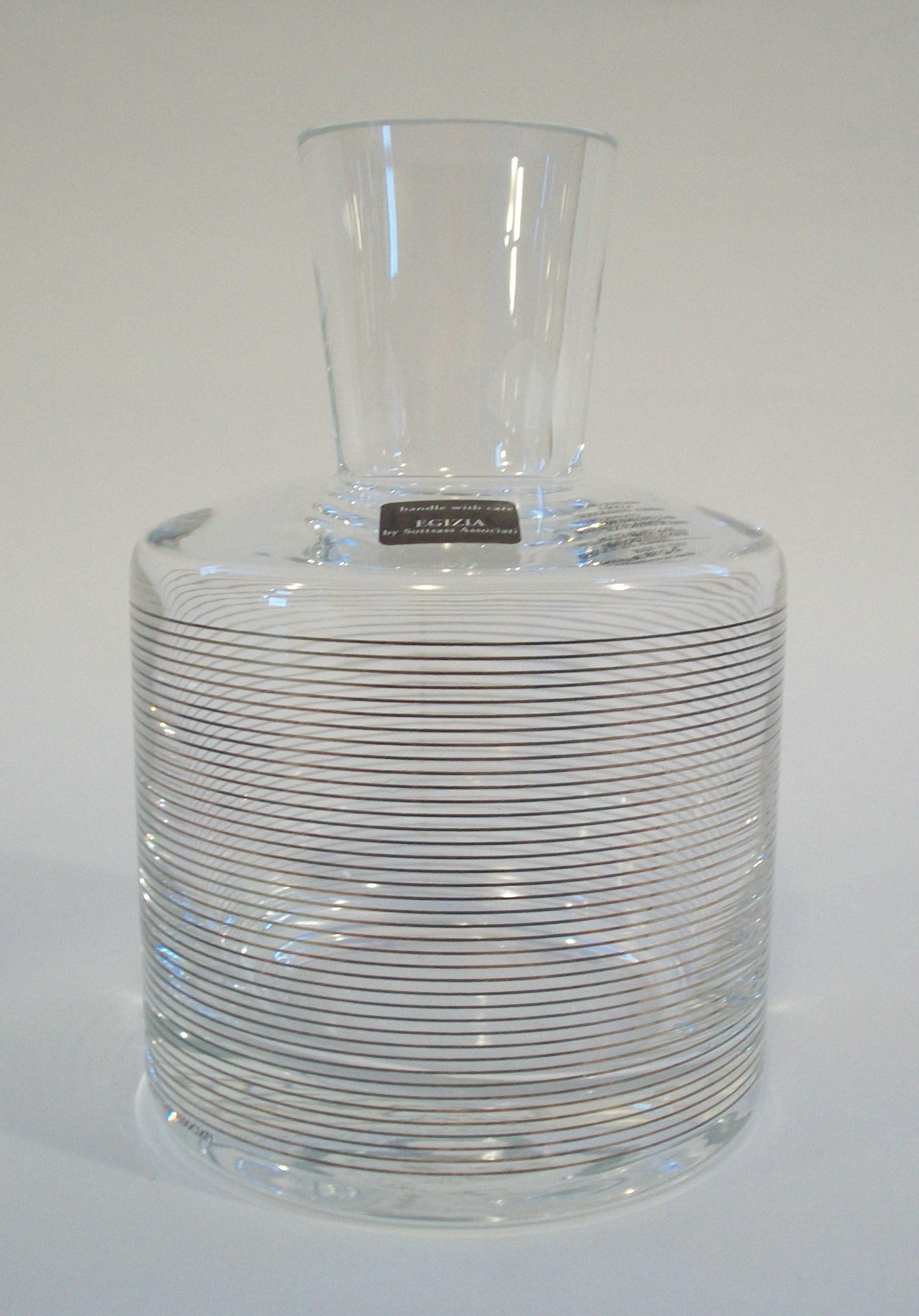 DEFNE KOZ for hwc EGIZIA by SOTTSASS ASSOCIATI - Retailed by Birks - Postmodern studio glass carafe - mouth blown - featuring a metallic horizontal stripe hand printed silkscreen pattern on the clear glass body - clear glass easy grip flared mouth -