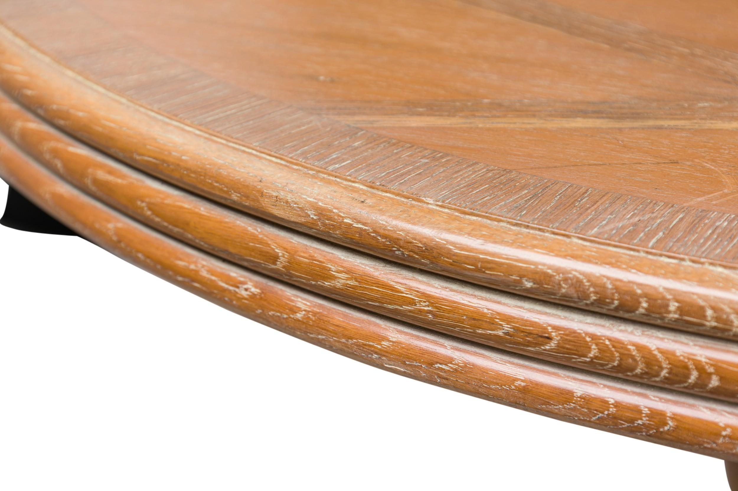 French Mid-Century (1950s) limed oak dining table featuring an inlaid diamond parquetry oval top with ribbed rim, supported on a quadrilateral sculptural base with the diamond pattern in relief. (SOUBRIER)
 

 Some wear to finish on top, scratches
