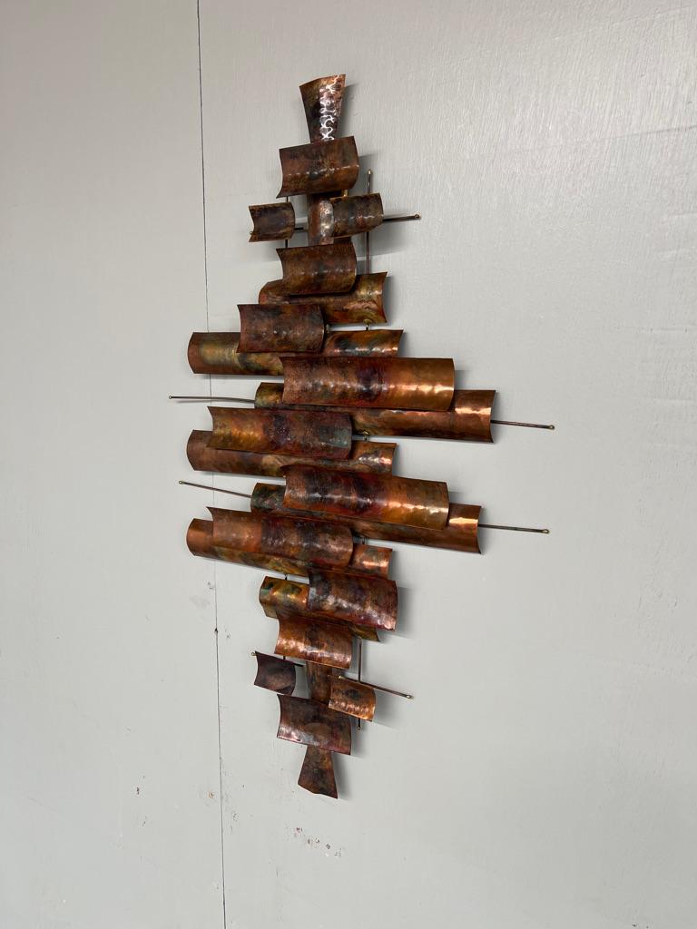 Presentiamo uno splendido pezzo d'arte moderna di metà secolo di Curtis Jere, risalente agli anni '60. Questa straordinaria scultura da parete misura 70 cm di altezza e 44 cm di larghezza, il che la rende un pezzo forte perfetto per qualsiasi