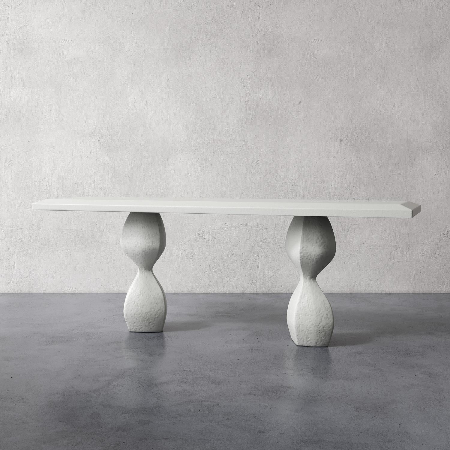 The Souple Sculptural Plaster Console Table showcases modern artistry with its two organically shaped, undulating legs that support a generously sized top surface. The wide faceted edge detail adds a bold, refined touch to the design, making it a