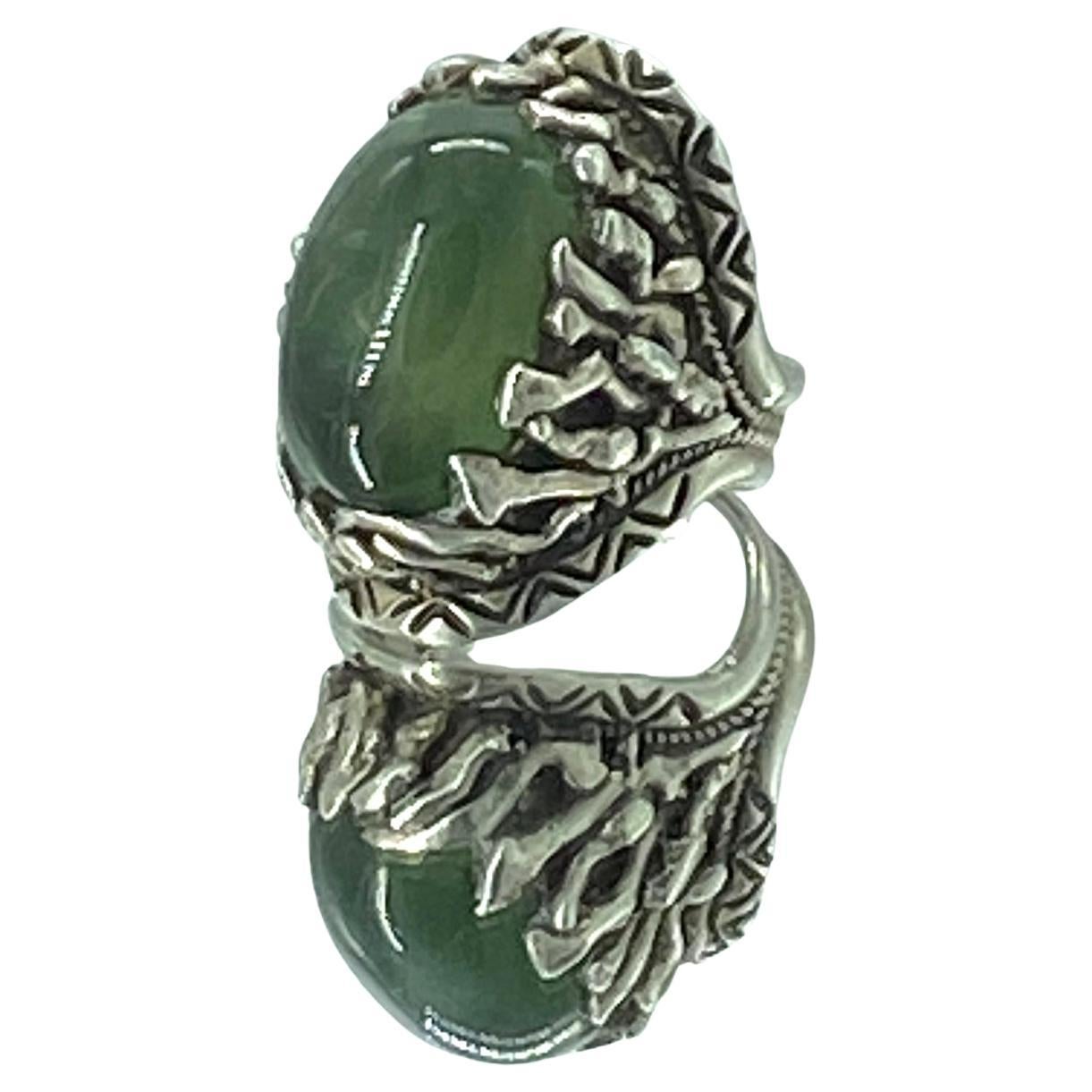 This is a large South African Prehnite sterling silver statement ring. It has a 25 mm x 15 mm translucent smooth cabochon bezel set in a sterling silver adjustable ring with natural coral like and incised patterns.

South African Prehnite is a apple