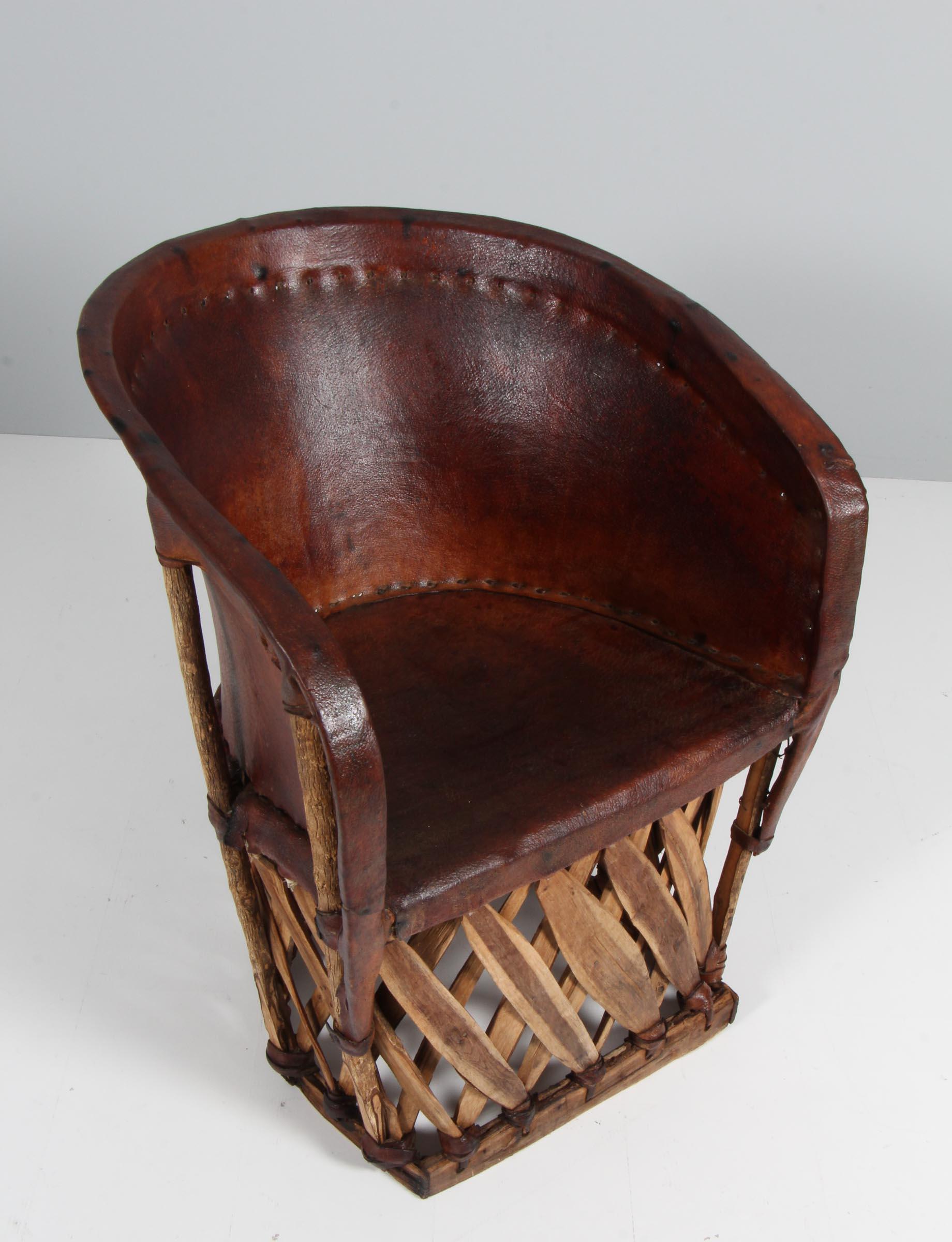 South American lounge chair made of palm tree wood and patinated leather.

Made in the 20th century.