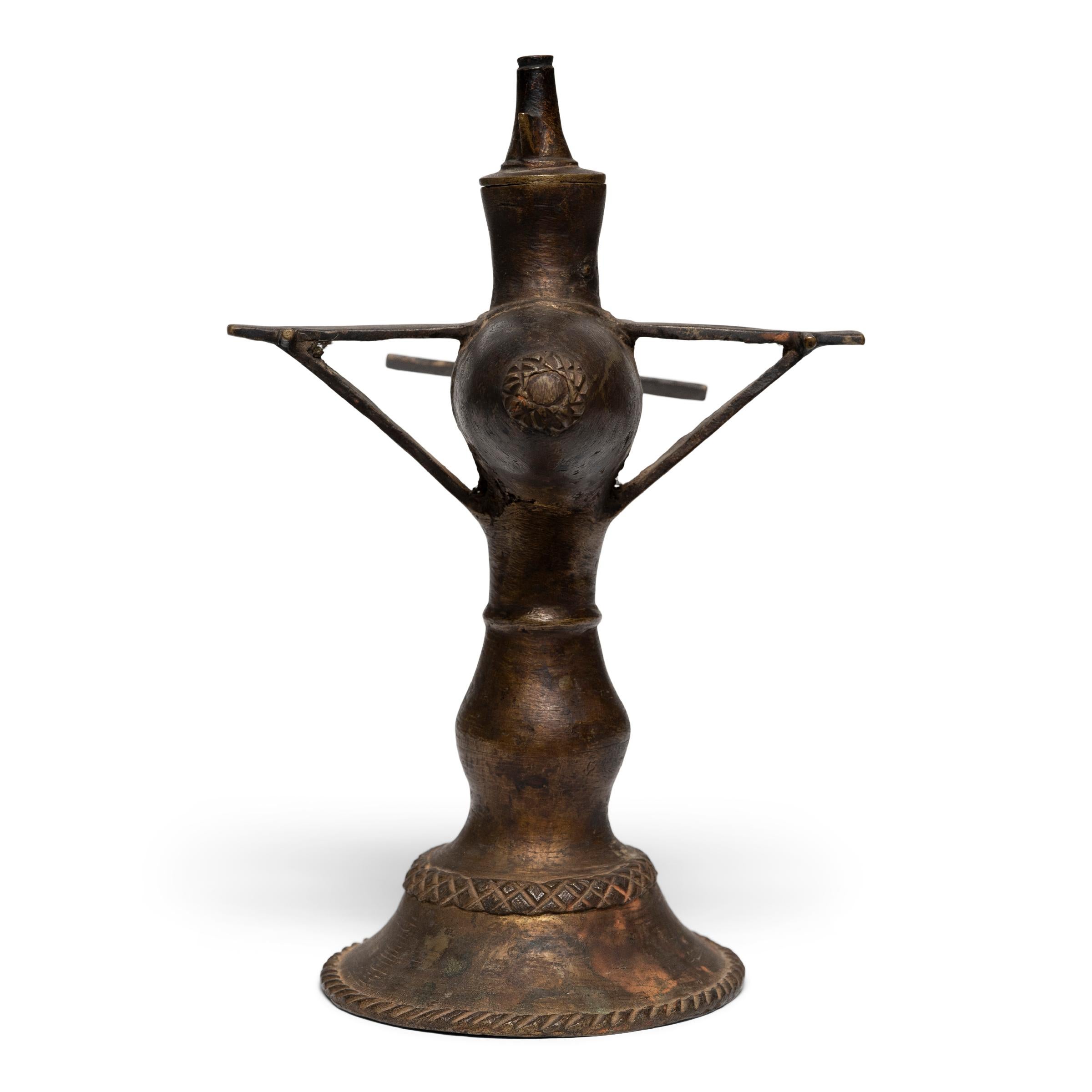 This 20th century South Asian oil lamp is made of brass in the shape of an aircraft. Oil lamps like these were likely handcrafted using the century old lost-wax process of metal casting where skilled artisans would pour molten metal into a mold that