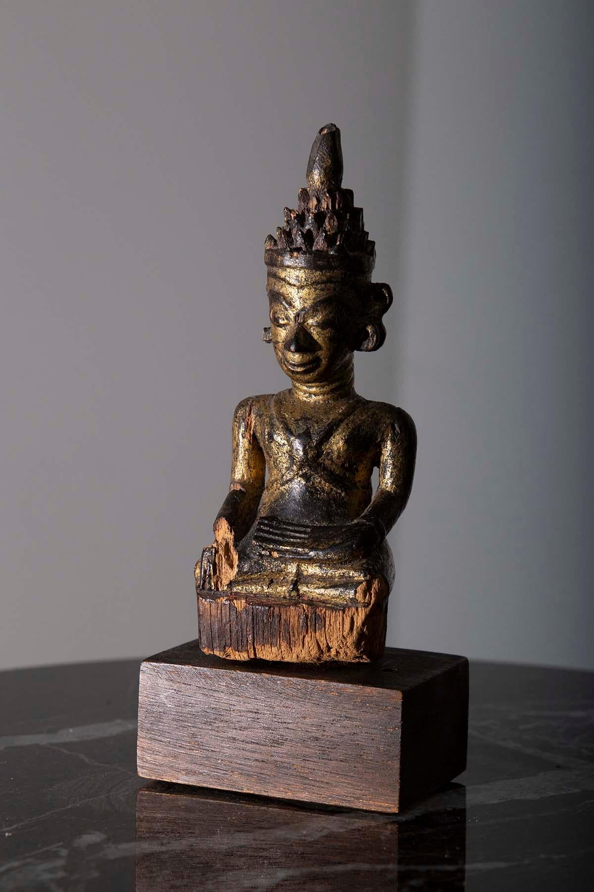 
In the midst of the 18th century, in the enchanting land of Burma during the Shan period, a magnificent masterpiece of spiritual artistry was born—an extraordinary Seated Burmese wooden crowned Buddha, often referred to as the 