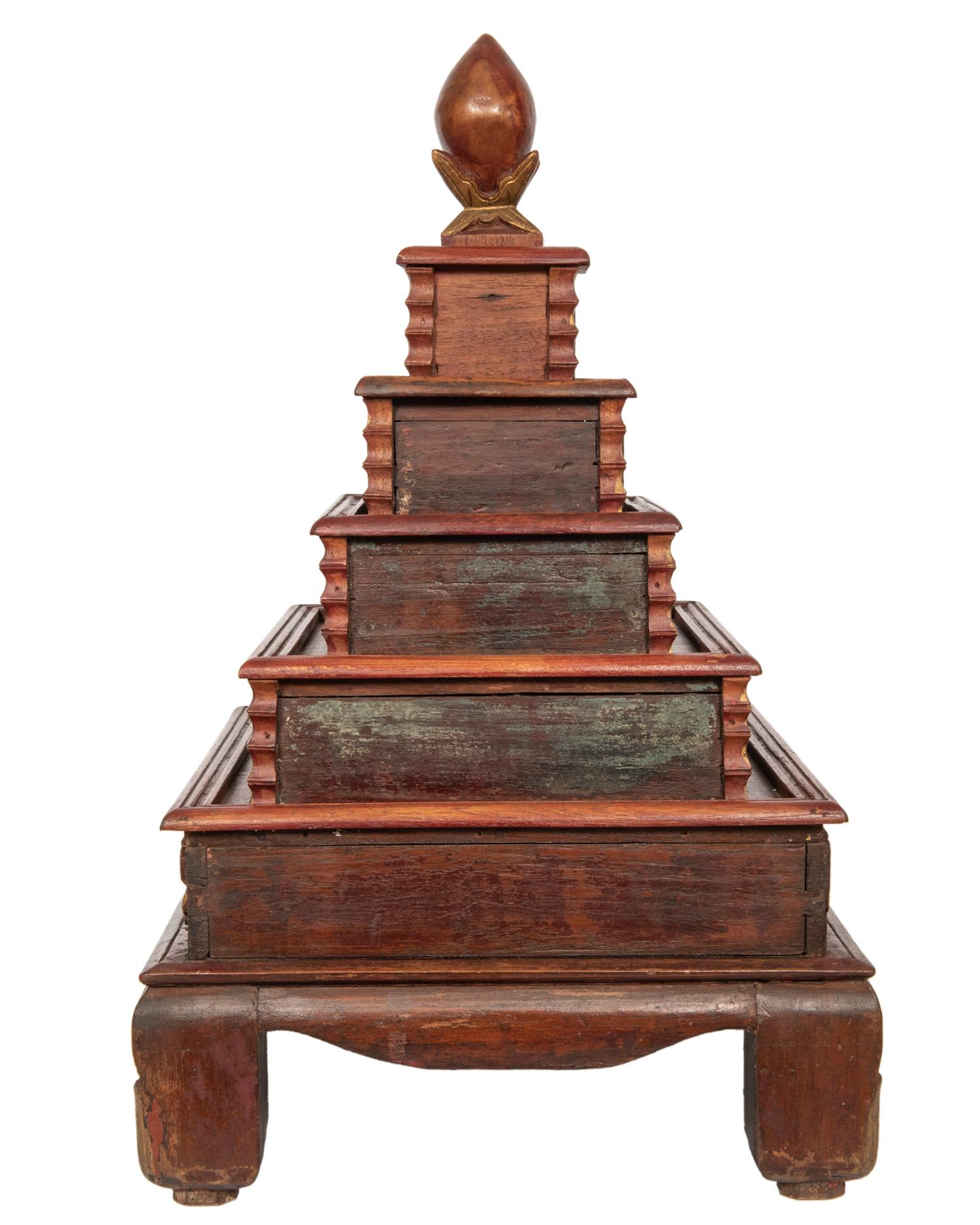 This highly decorative red and gold painted wood stacking pyramid box contains five graduated
drawers with brass pulls.