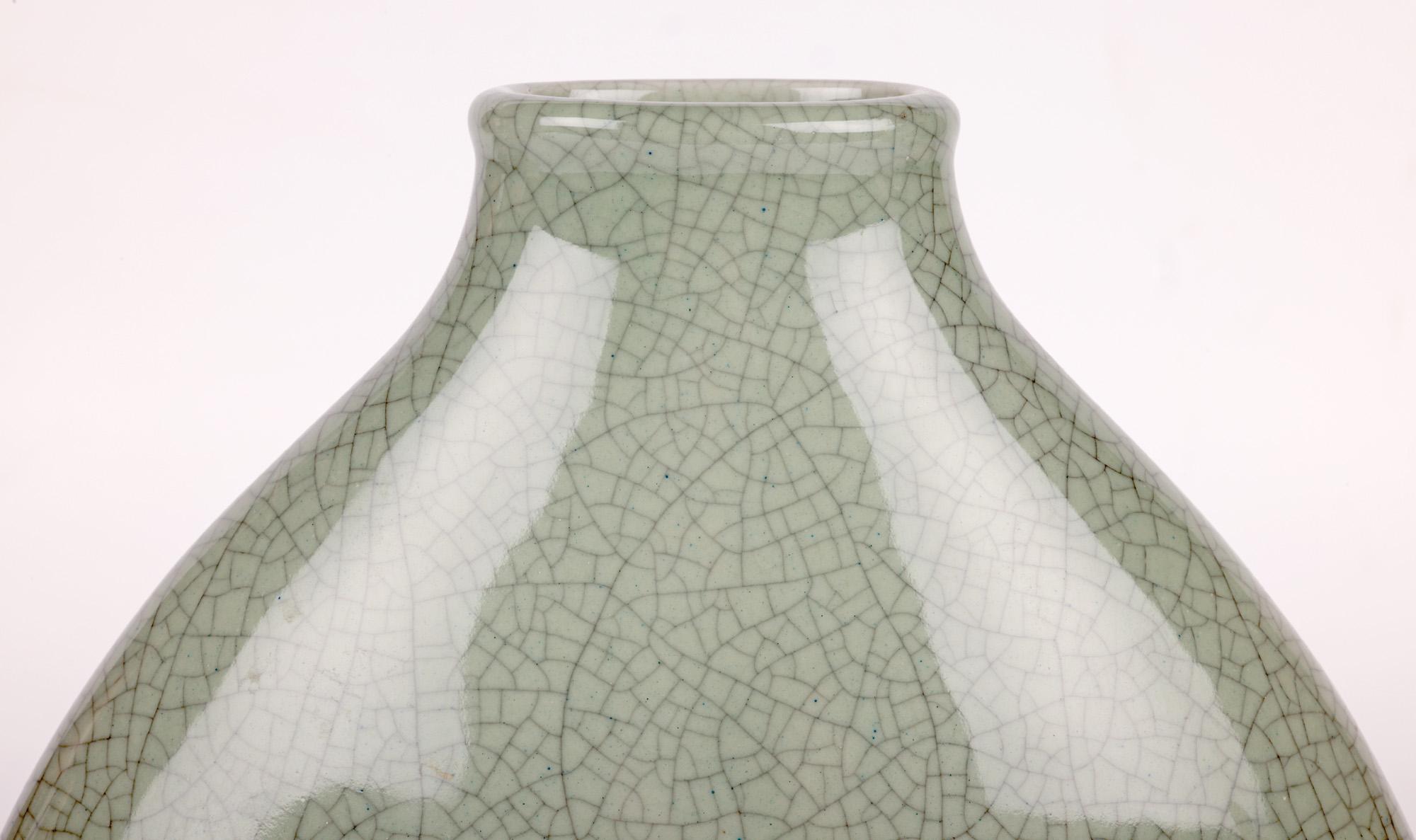 A very stylish South East Asian porcelain celadon craquelure glazed bottle shaped vase probably Chinese or Korean and dating from the 20th century. The finely made vase is of flattened oval shape with a wide narrow oval shaped unglazed foot and