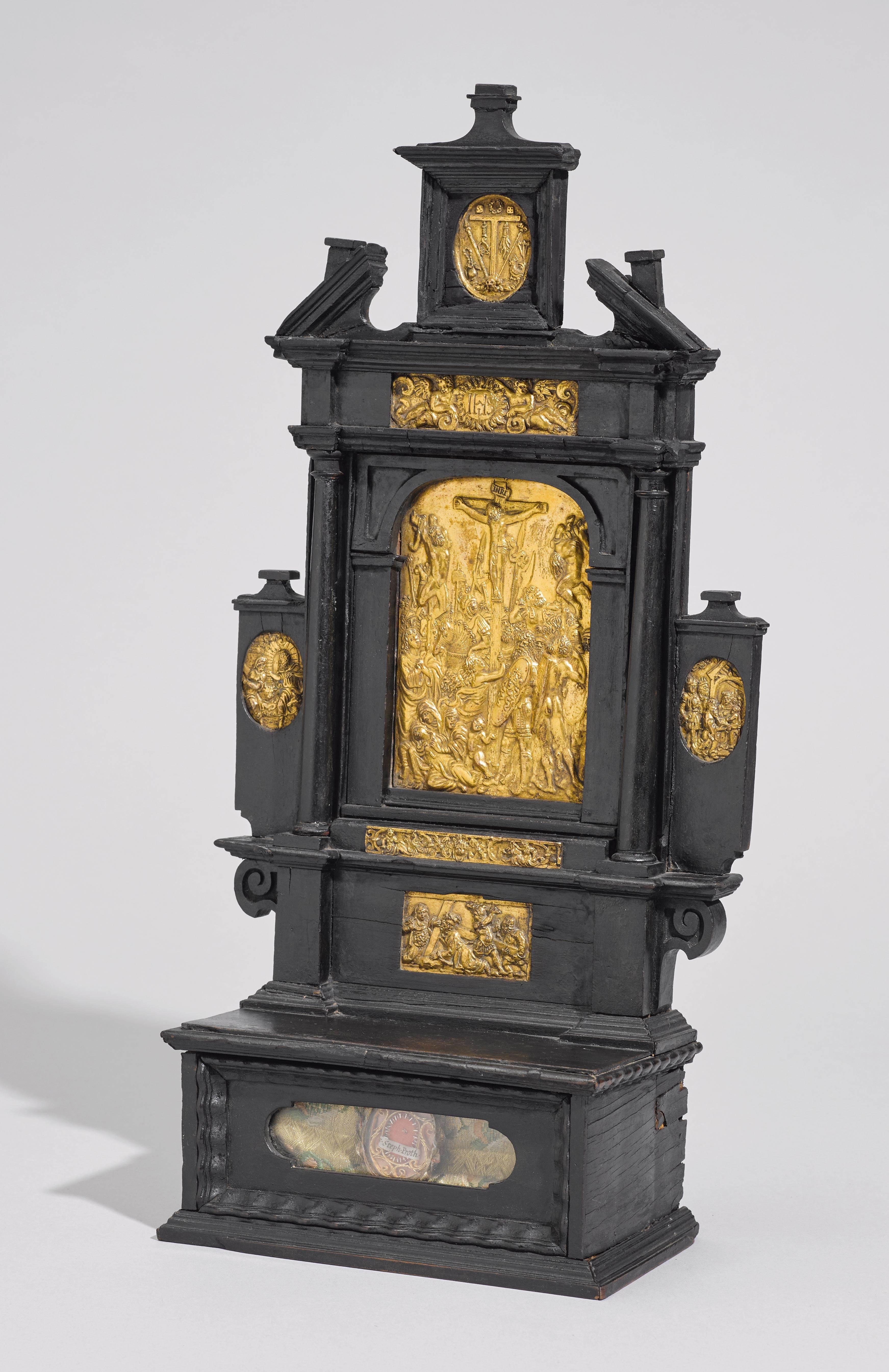 Attributed to the “Augsburger Plakettenwerkstatt.”
Augsburg, Germany, ca. 1575-1600

Approximate size: 21 x 9.5 x 40 cm.

Ebonized wooden House Altar inlaid with handsomely chased and gilt bronze plaquettes set upon a plinth containing a relic