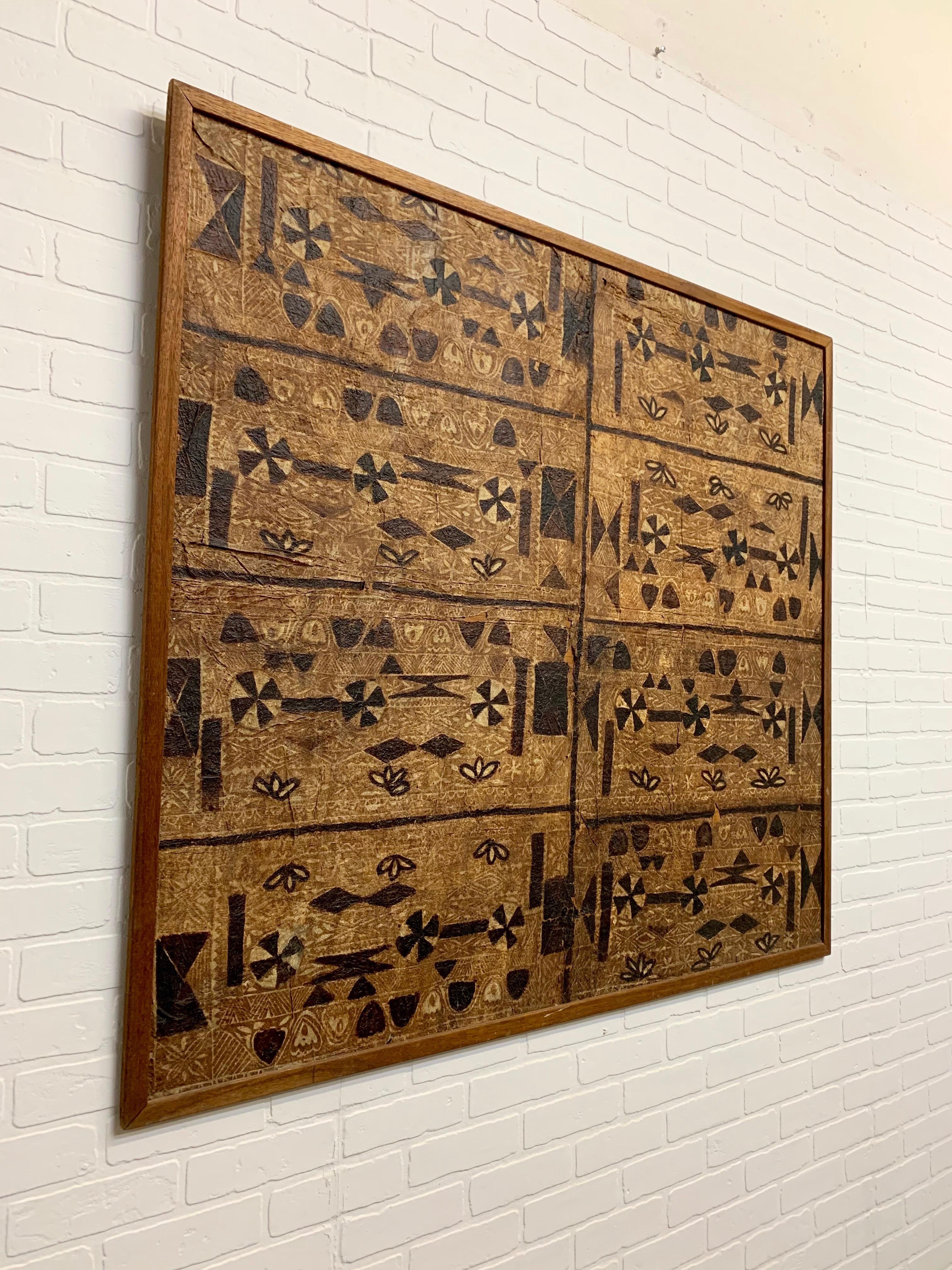 Bark cloth or tapa cloth mounted on plywood and trimmed in mahogany.

Bark cloth, or tapa, is not a woven material, but made from bark that has been softened through a process of soaking and beating. The inner bark is taken from several types of