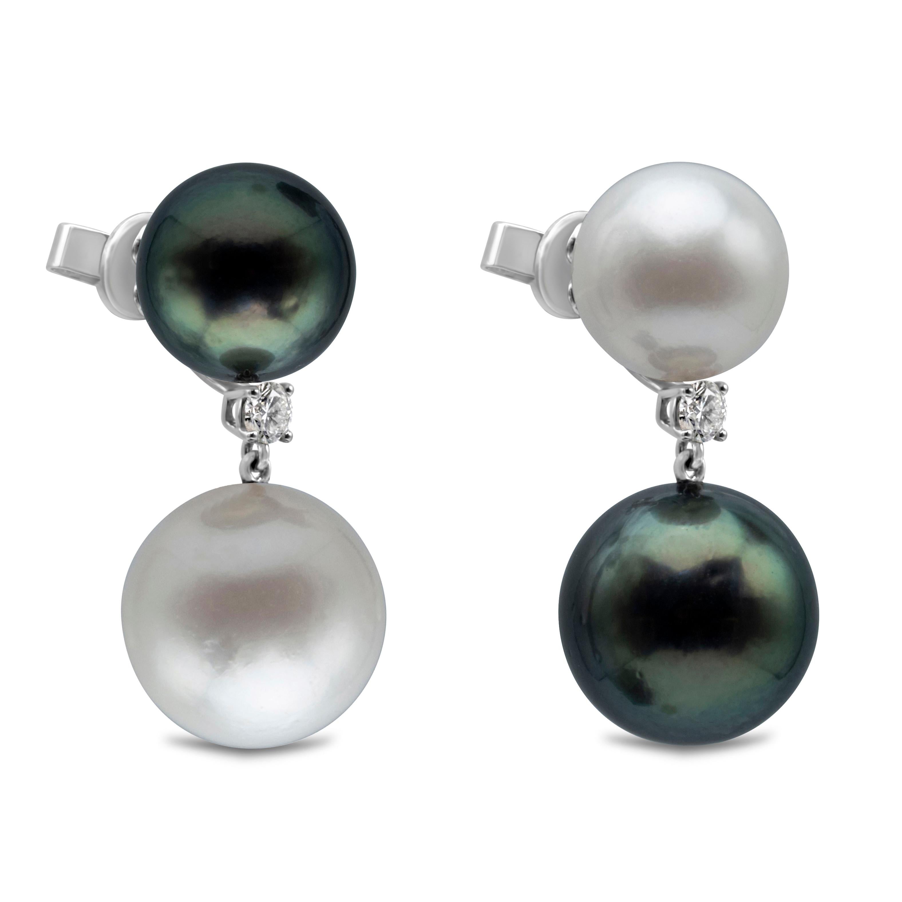 A lustrous dangling pair of pearl earrings showcasing South Sea and Tahitian Pearls, 11-14mm in diameter. Amazingly matched pearls are suspended in a single round diamond weighing 0.25 carats. Made in 18k White Gold. 

Style available with matching
