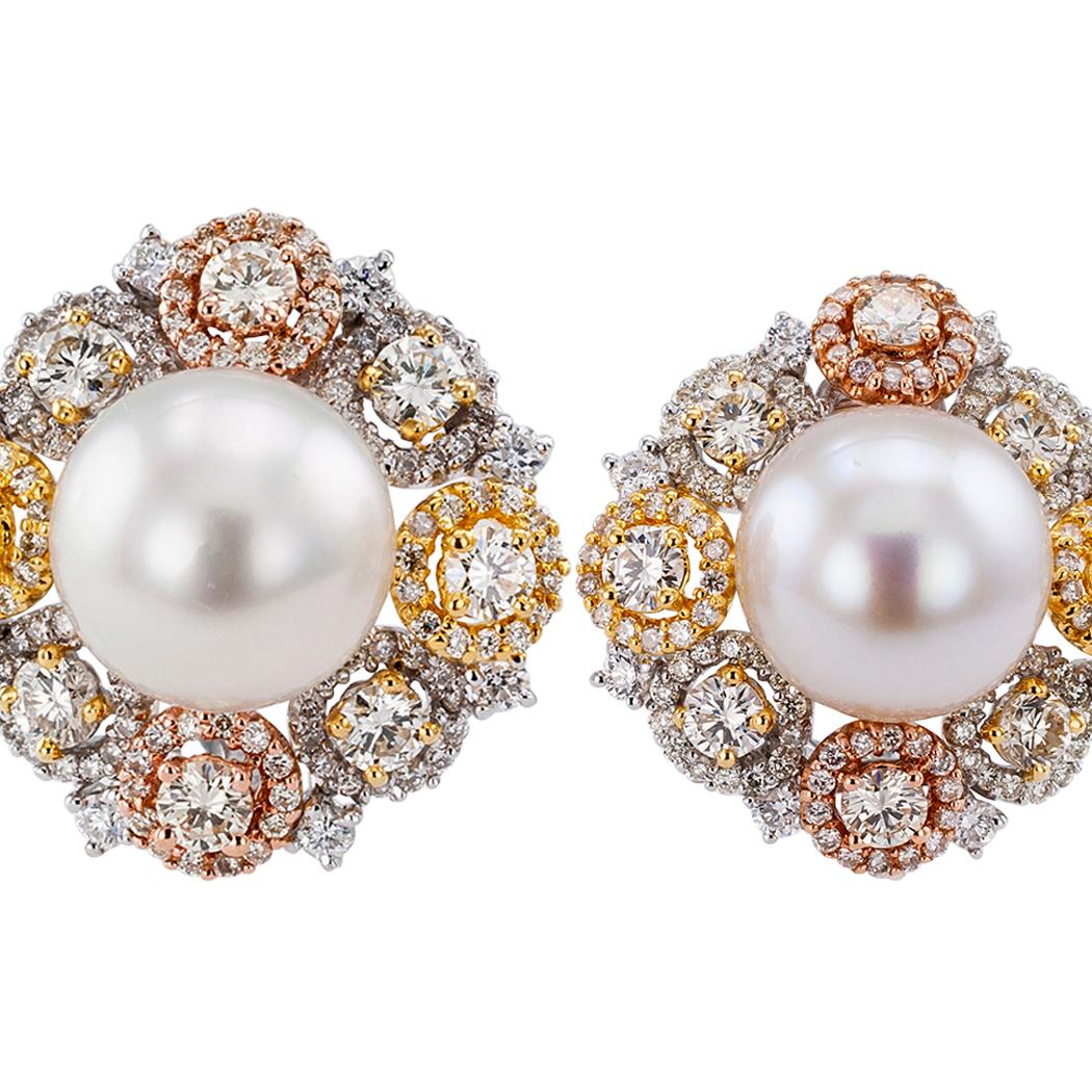 South Sea button pearl diamond gold ear clips. Showcasing a pair of South Sea button pearls measuring 11.65 mm, within a diamond border comprising eight round diamonds set at equal intervals, in turn, each inside its own diamond halo, the color of