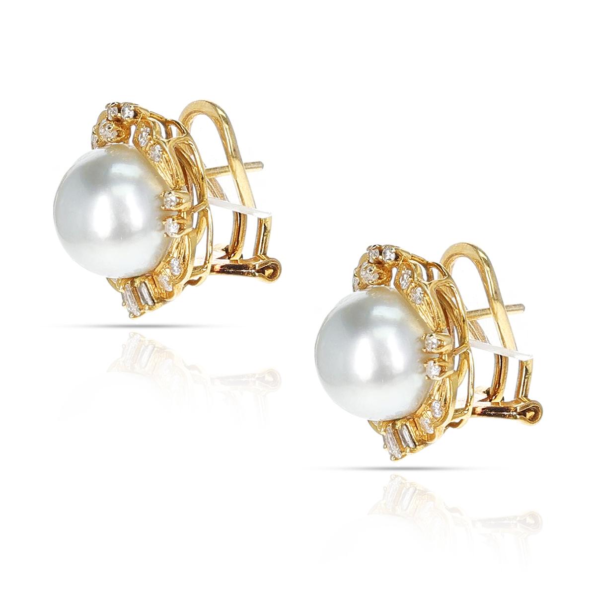 A beautiful and elegant pair of south sea cultured pearl (11.5MM) earrings, with a total of 30 round diamonds and 6 tapered baguette diamonds. Pierced clip back earrings, Length: .75” Stamped 14K.