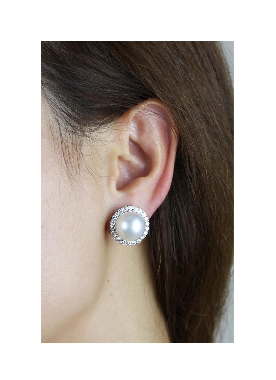 Elegant pearl and diamond earrings set in 18 carat white gold. Formatting of a singular powerful, perfectly round, pearl in the centre and surrounded by round brilliant cut diamonds. A statement jewellery embracing modern pizzazz and vintage classy