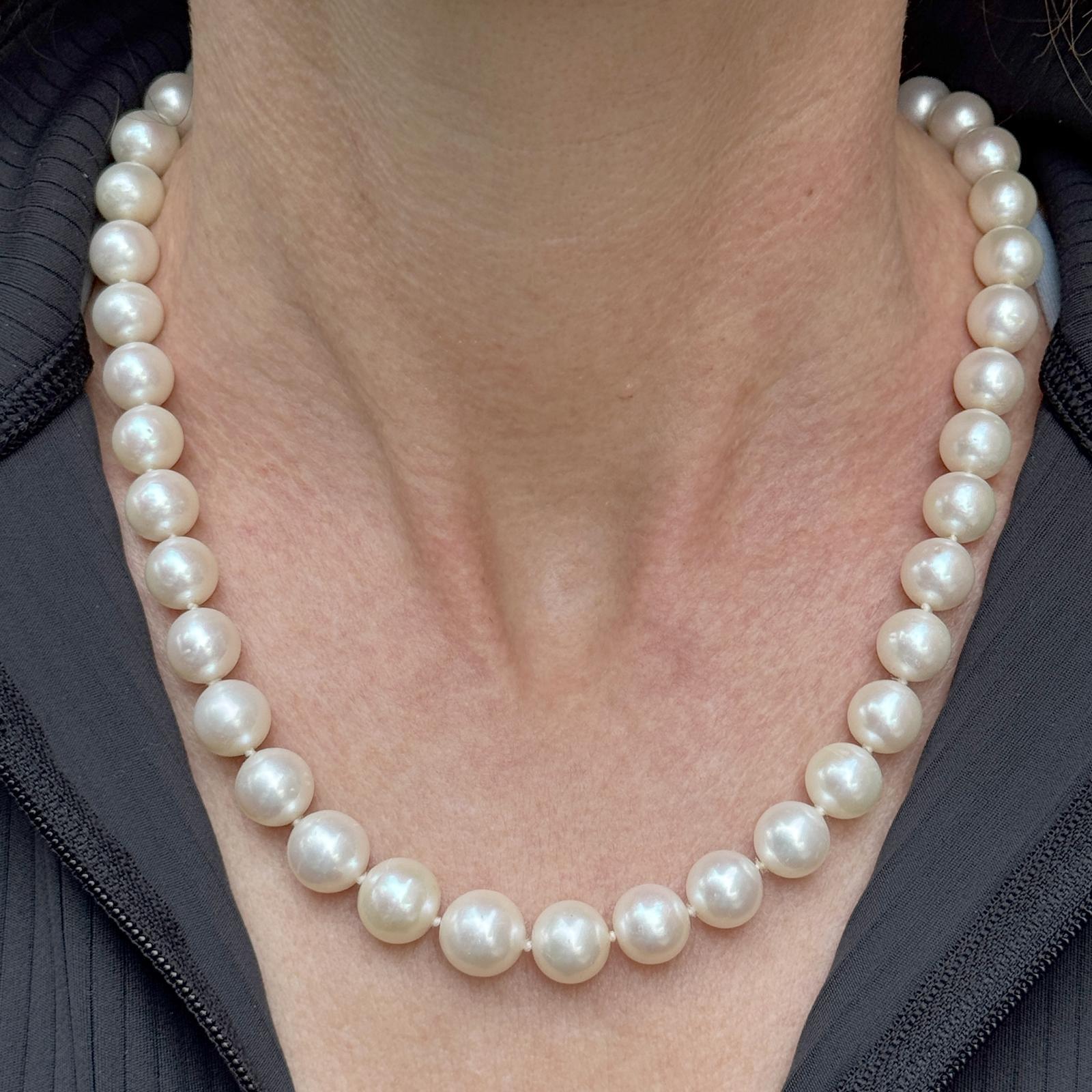 This exquisite South Sea pearl necklace showcases cultured pearls ranging from 9.75mm to 11.50mm, displaying a luxurious luster and smooth surface. The 17.5 inch strand is elegantly secured with a 12 diamond (.36 CTW) 14 karat white gold ball clasp,