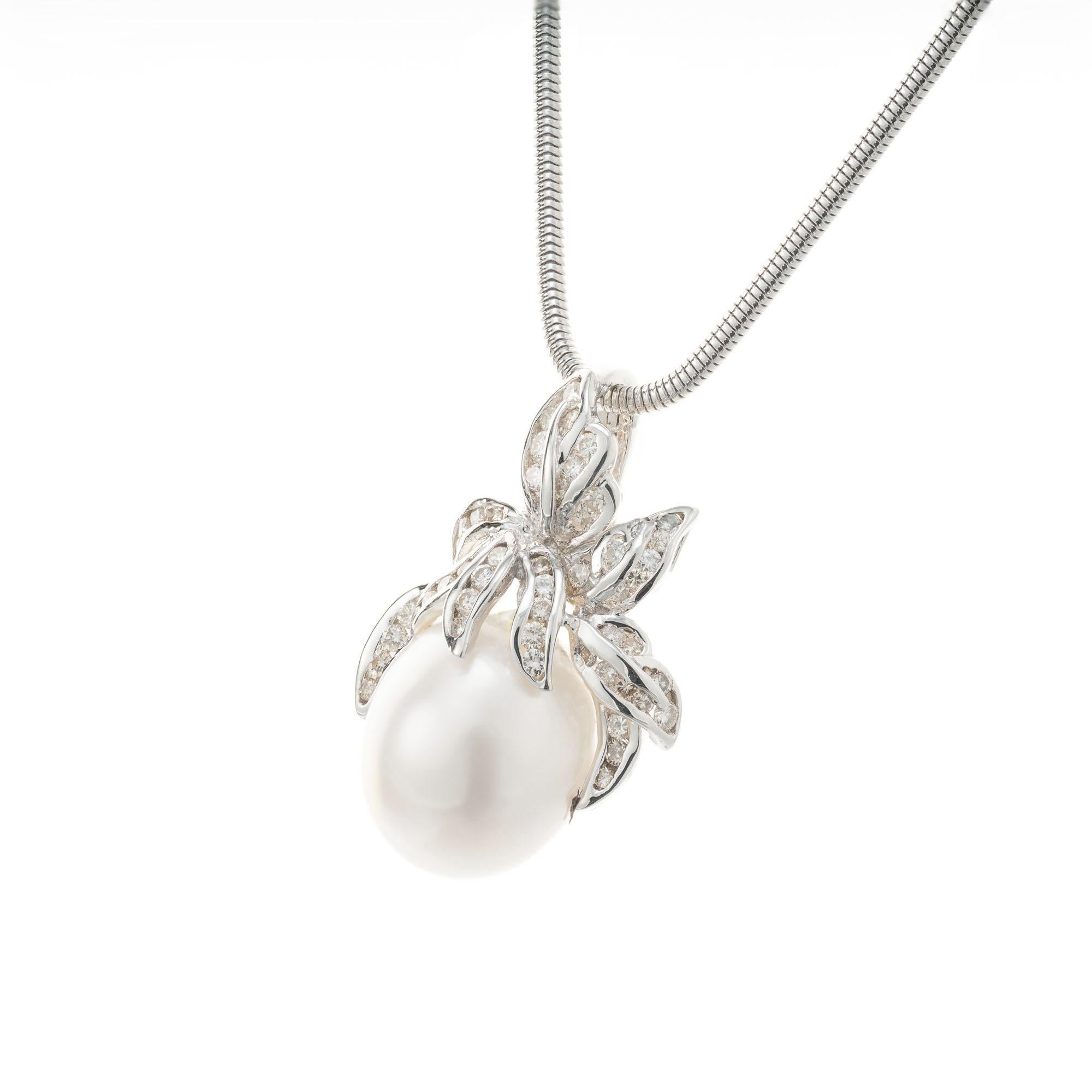 South Sea cultured pearl pendant with a swirl diamond top on an 18k white gold snake 18 inch chain. The pendant top hinges open to go over pearls as well. 

1 Baroque South Sea pearl, white grey hue, good lustre slight blemishes. 15.5mm x 12.8mm
53