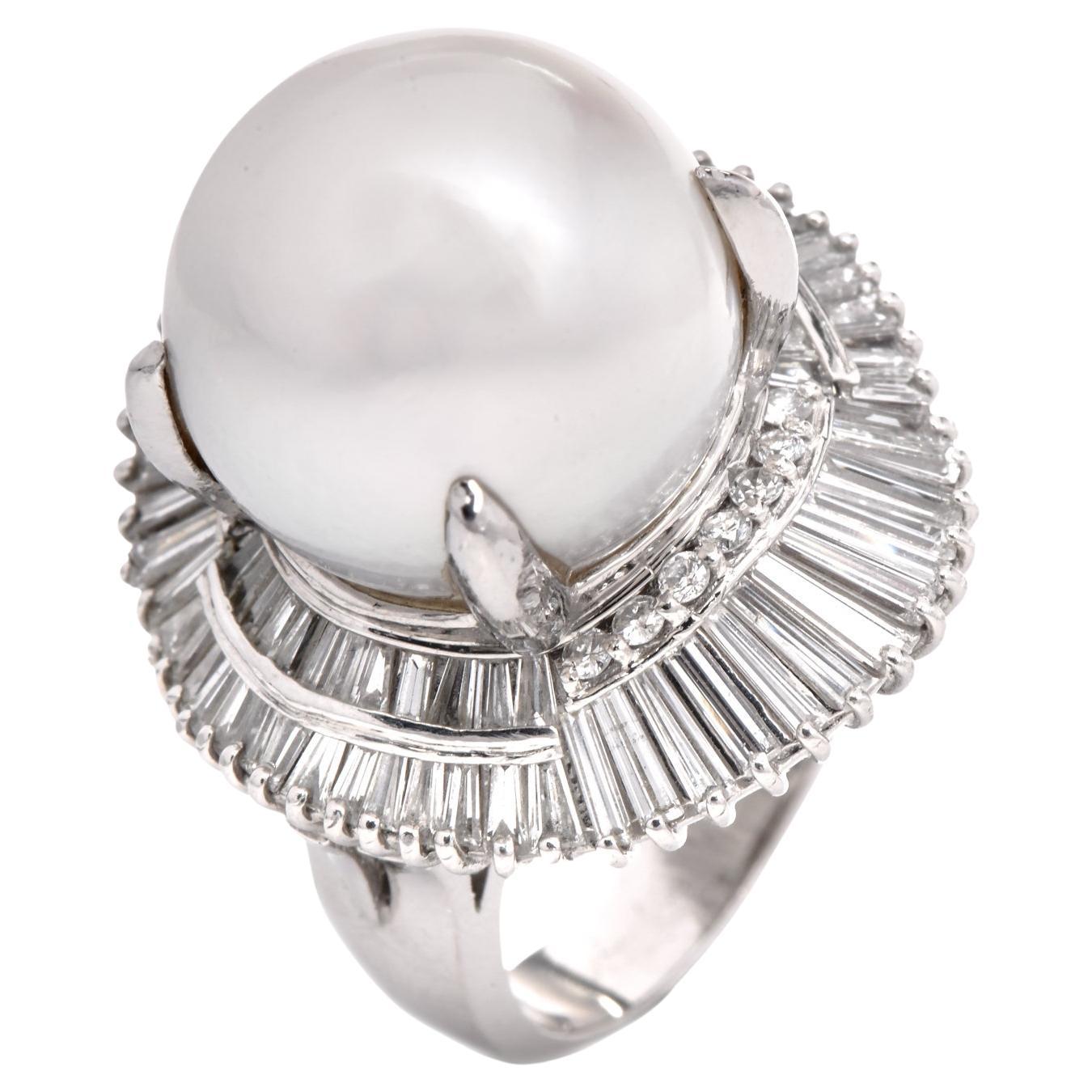 Cette impressionnante bague de ballerine est fabriquée en platine massif. Elle pèse 25,7 grammes et mesure 21 mm de large et 19 mm de haut. Cette bague de cocktail séduisante est centrée sur une perle lustrée de mer du Sud de couleur blanc crème,