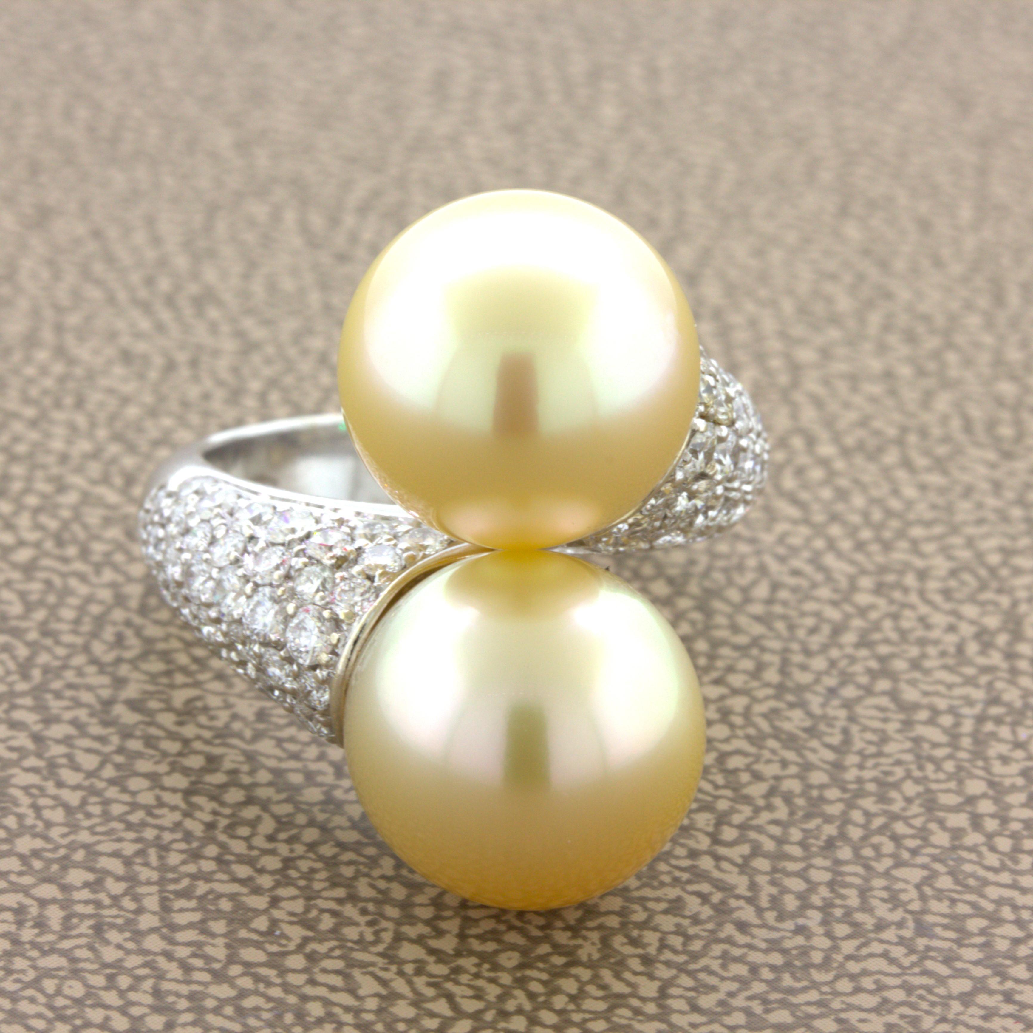A chic and stylish ring featuring two golden South Sea pearls. They measure 12.5mm each in diameter and match in their bright golden color with excellent nacre quality making them glow in the light. They are complemented by 1.20 carats of bright