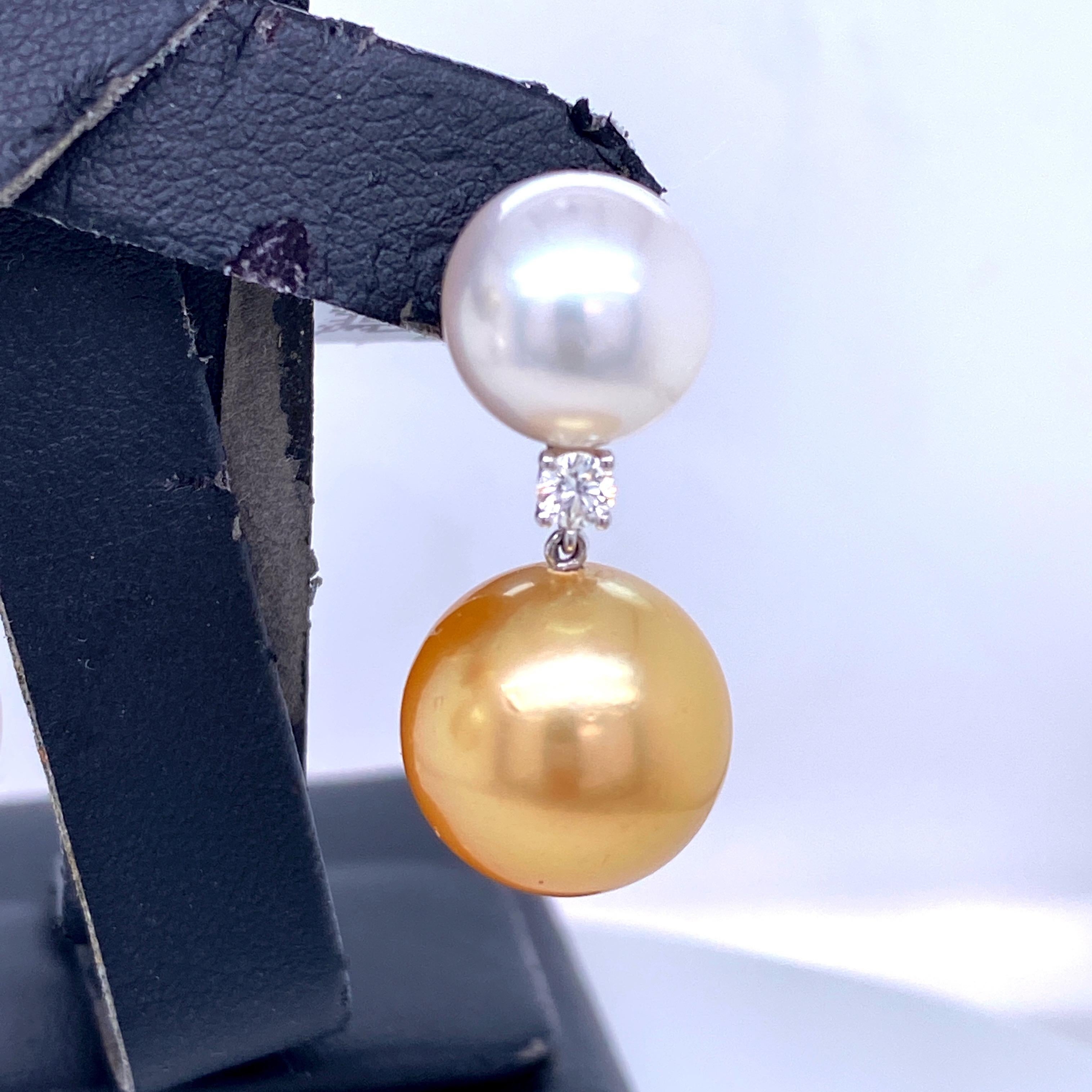 Orecchini a goccia in oro bianco 18K con due perle South Sea e Golden Pearls di 11-14 mm e 2 brillanti rotondi di 0,25 carati. Gli opposti si attraggono!
Colore G-H
Chiarezza SI