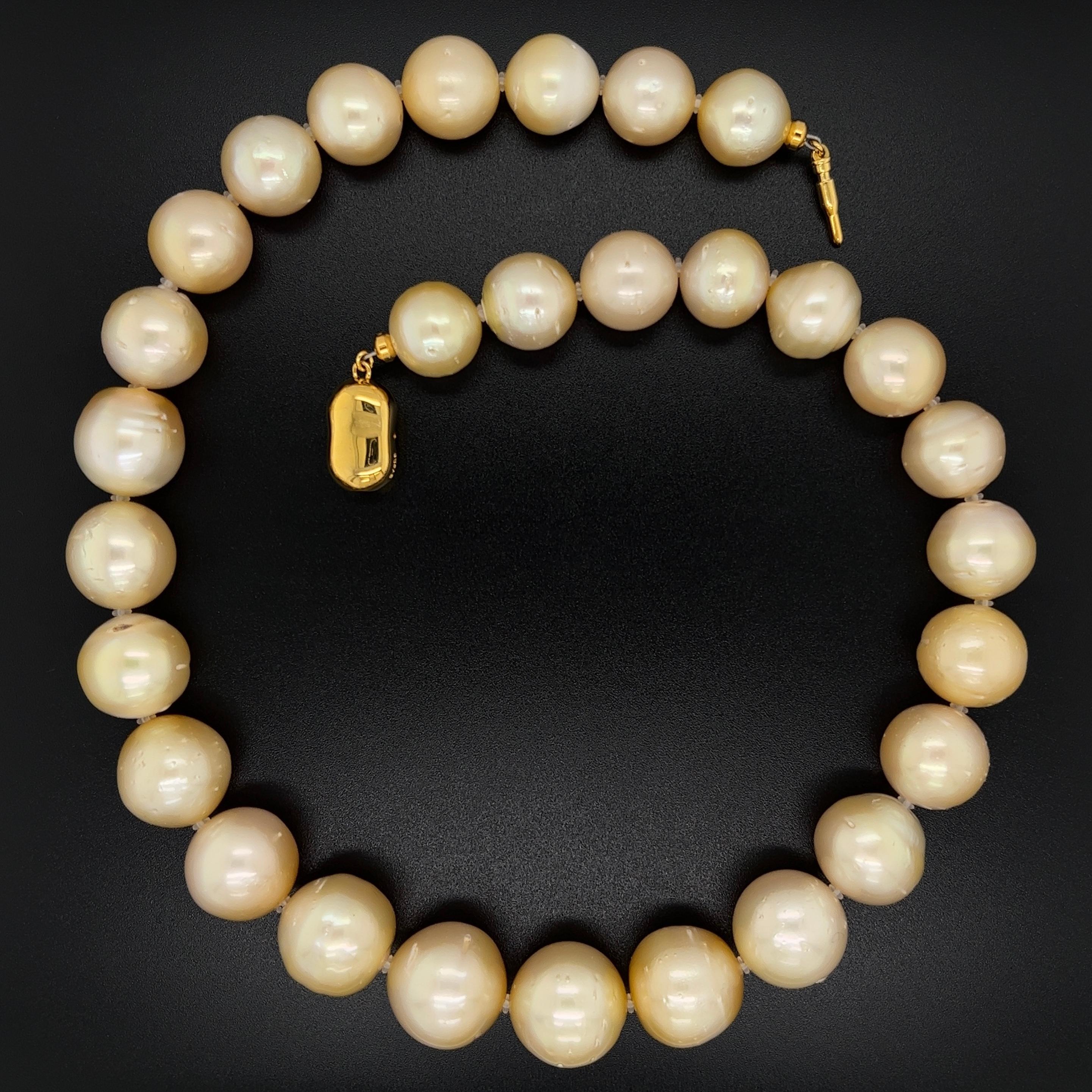 Simply Beautiful! South Sea Golden Pearl Necklace, comprising 29 South Sea Golden Pearls, each approx. 15.8mm - 12.3mm held by a 925 Yellow Gold clasp. Natural Blemishes. Hand strung with matching silk cord. The necklace measures approx. 17” long.