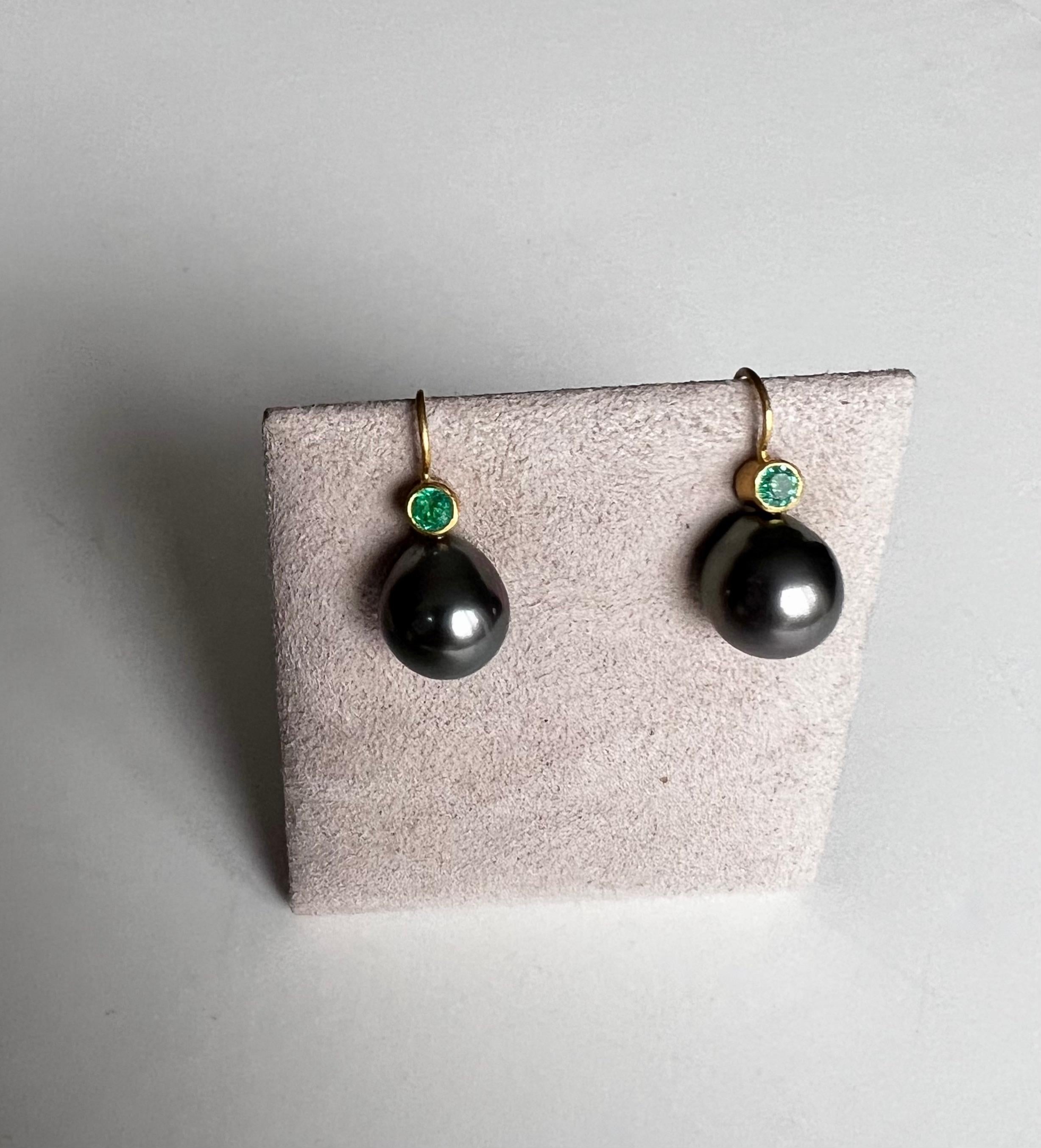 Beautiful grey Tahitian Pearls paired with vibrant Columbian Emeralds set in 22 Karat gold and 20 Karat earwires.
The Emeralds are 4 millimeter round and weigh .70ct  The Pearl is 12 millimeter at widest point.
The earrings hang 1