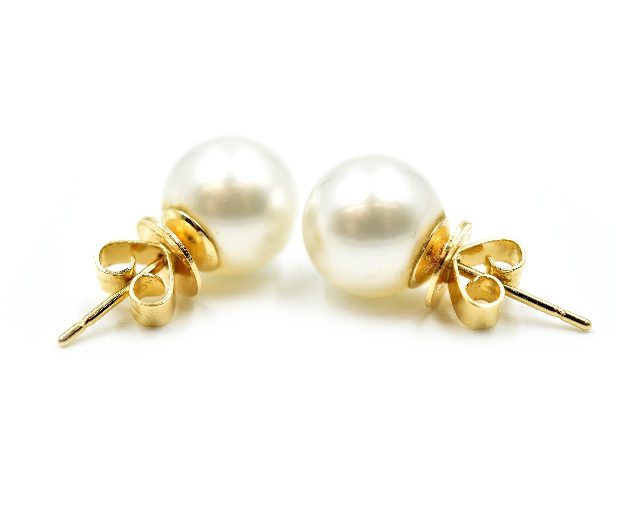 This classic pair is designed in 18k yellow gold. Each stud features a 9mm south sea pearl. The pearls are white with beautiful silver overtones. Each earring is secured with a friction back fastening. The pair weighs 3.1 grams. 