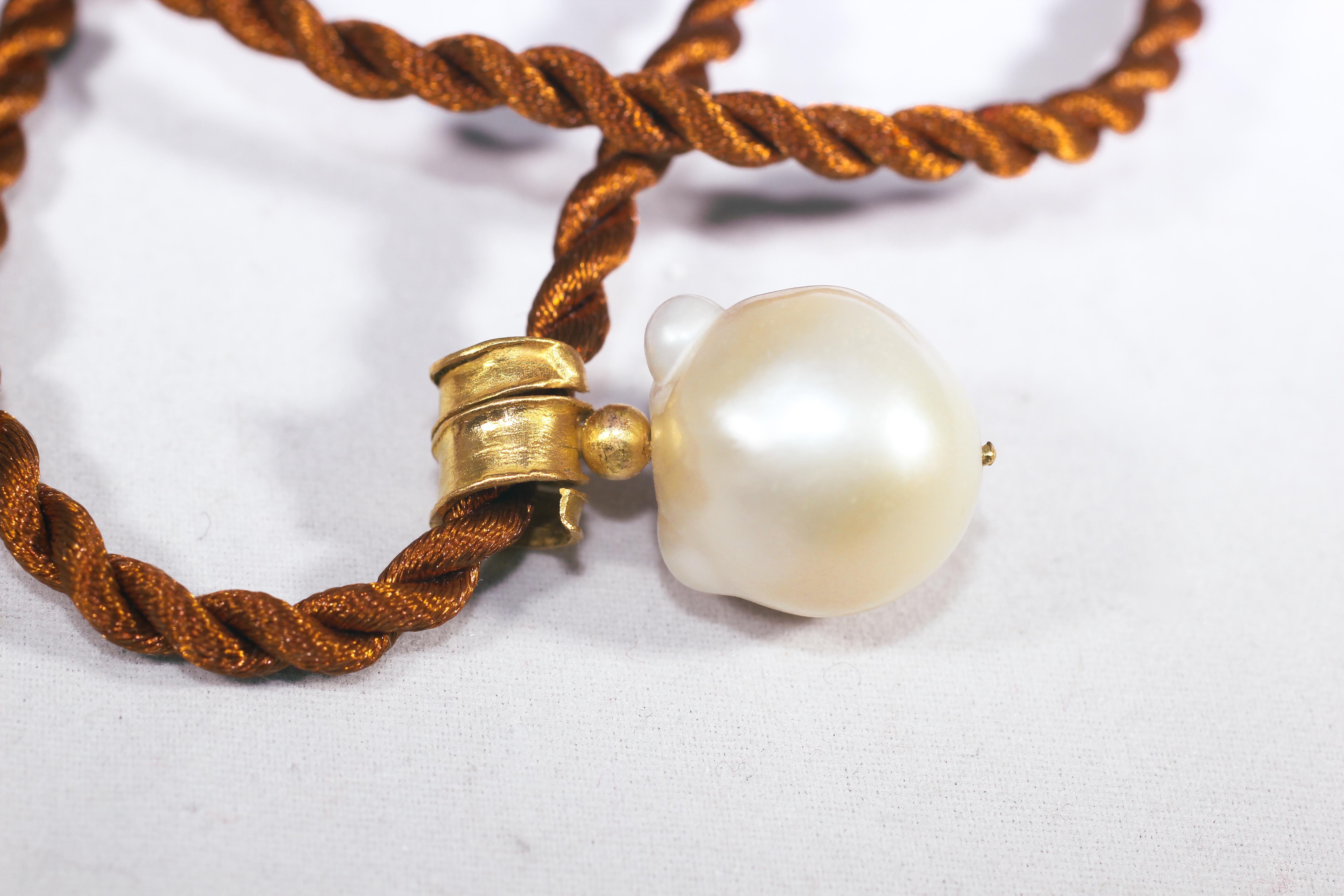 In The Sea South Sea pendant. Made to order, custom-made hand-formed choker pendant necklace. White Baroque South Sea pearl hangs off of organically shaped bail hand forged of 21K gold. No two necklaces are identical. 

The inspiration for this