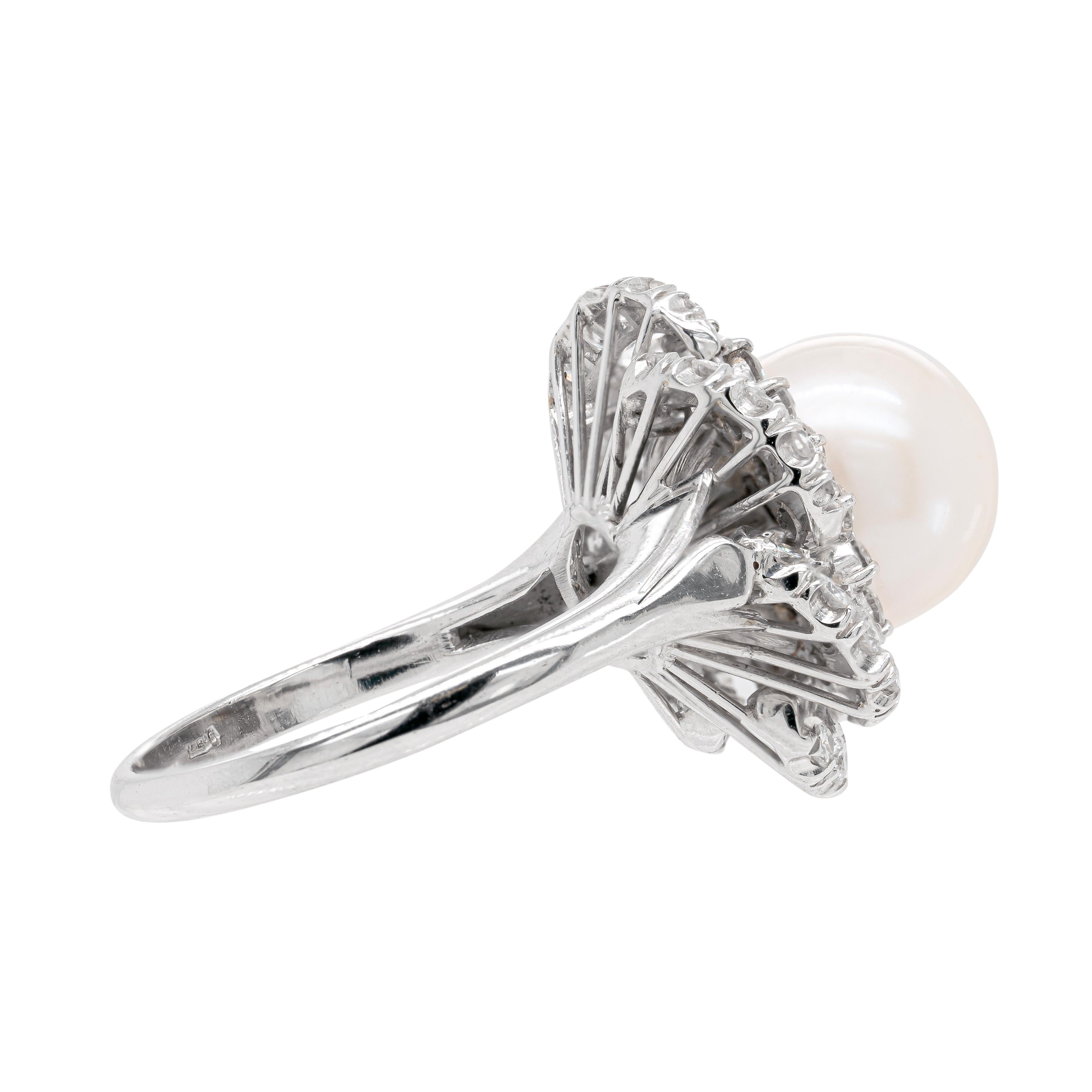 This exquisite 18 carat white gold cluster ring features a gorgeous south sea pearl measuring 10.8mm, beautifully surrounded by 18 fine quality round brilliant cut diamonds. The wonderful ring is further designed with six delicate gold swirls, each
