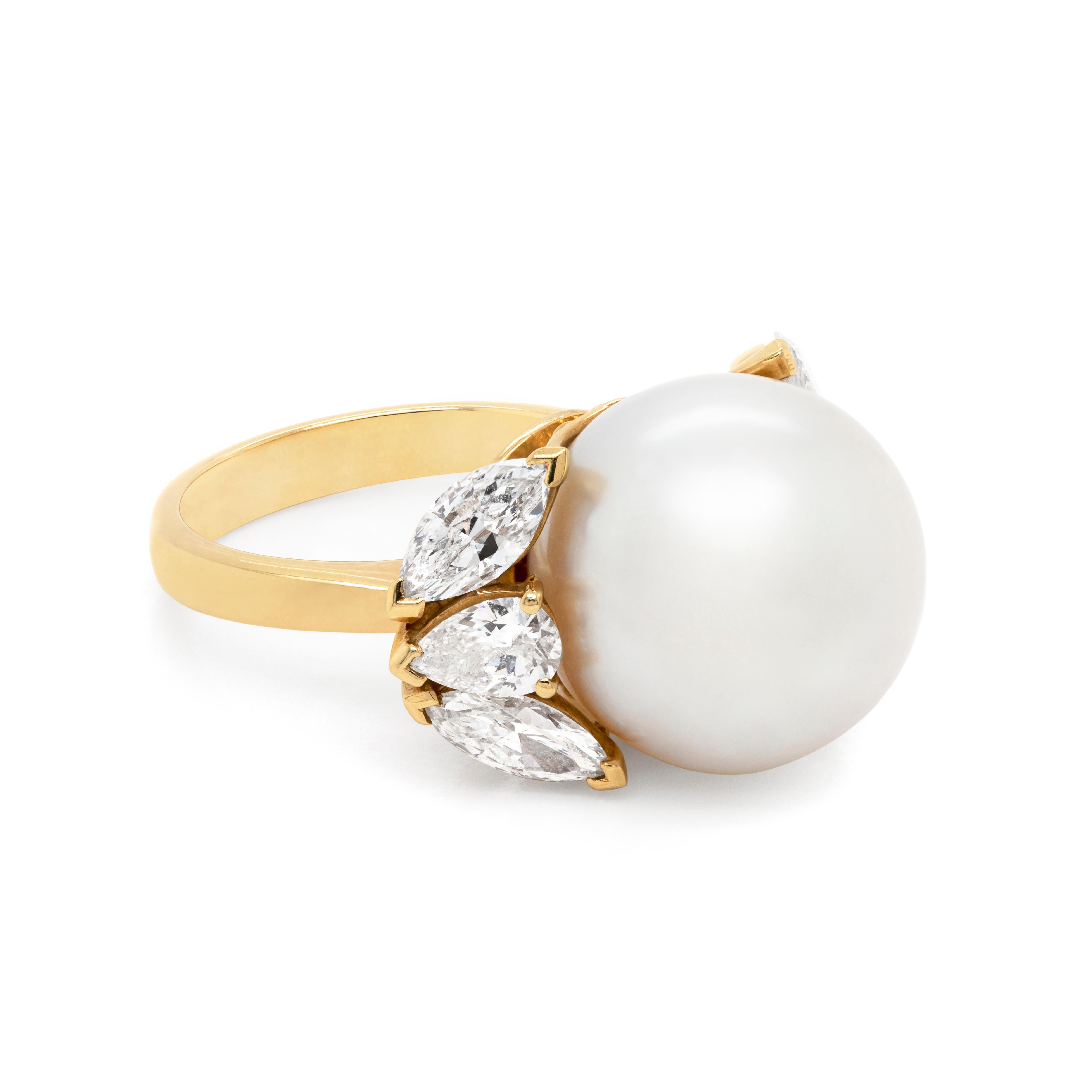 This handmade dress ring features a beautiful cultured white South Sea pearl measuring 14.5mm in the center accompanied by a trilogy of diamonds hugging the pearl on either side. The stones consist of two marquise shaped diamonds weighing