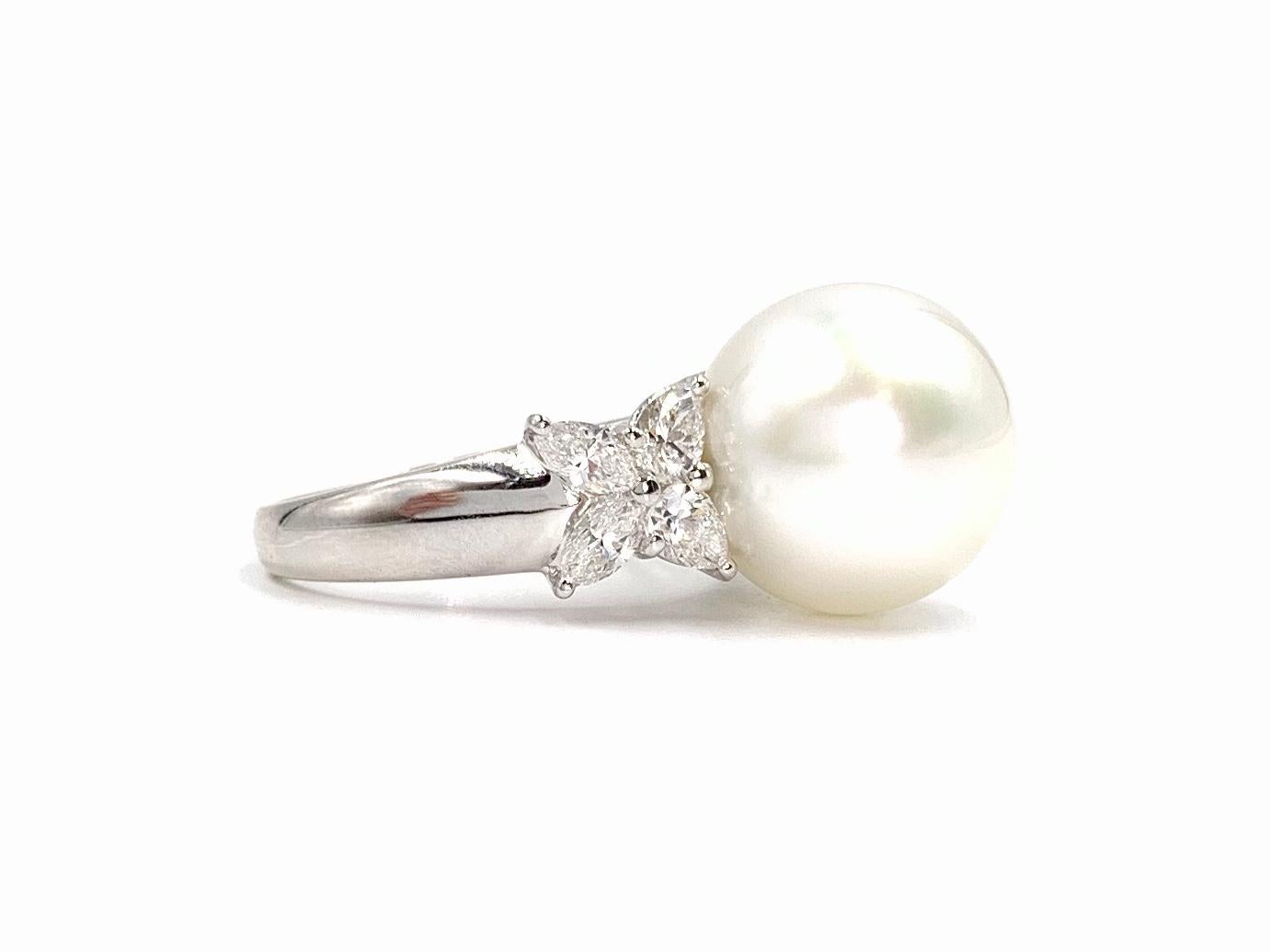 A sophisticated and classically designed 18 karat white gold cocktail ring featuring 1.20 carats of pear shape and marquise cut diamonds and showcasing a 13.4mm lustrous white genuine south sea pearl. Pearl has a beautiful evenly round shape and