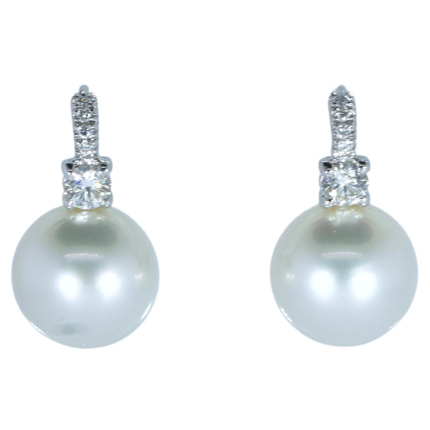 Large and fine white South Sea pearl and diamond earrings. Luxuriate in the knowledge that these are perfectly spherical, blemish free, high luster, deep -nacred silver white south sea pearl well identically matched specimen south sea pearls. 