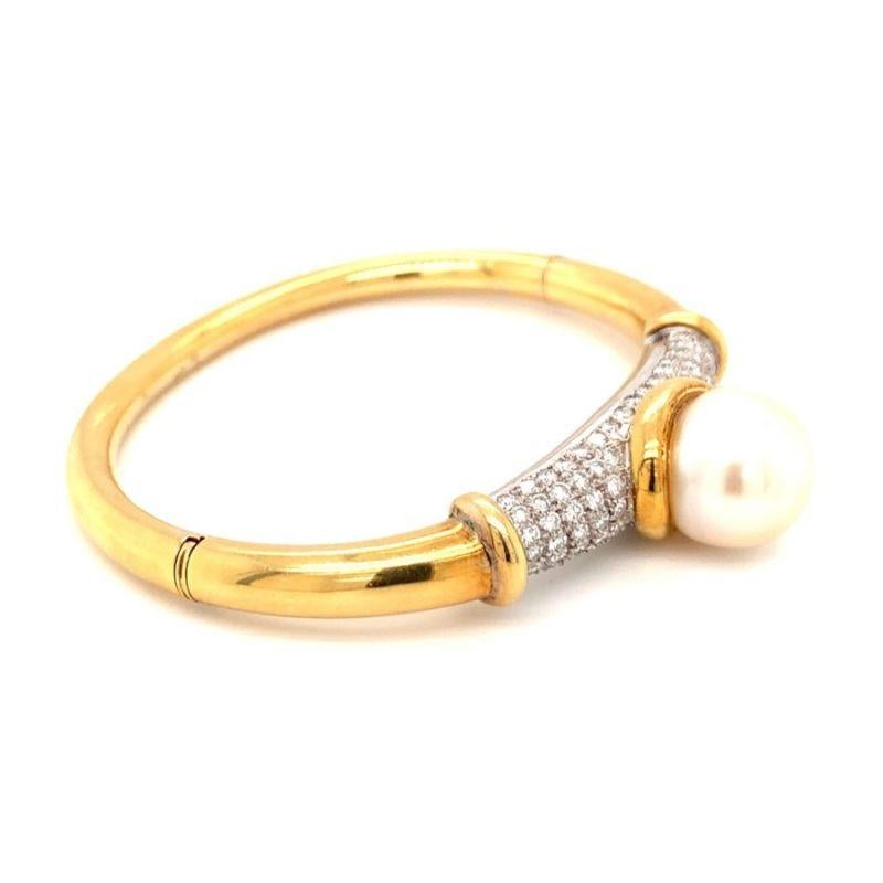 One South Sea pearl and diamond 18K yellow gold bangle bracelet centering one round cultured, cream color South Sea pearl measuring 14 millimeters in diameter. Enhanced by 84 round brilliant cut diamonds totaling 1.75 ct. Matching set with RO.WJ.20.