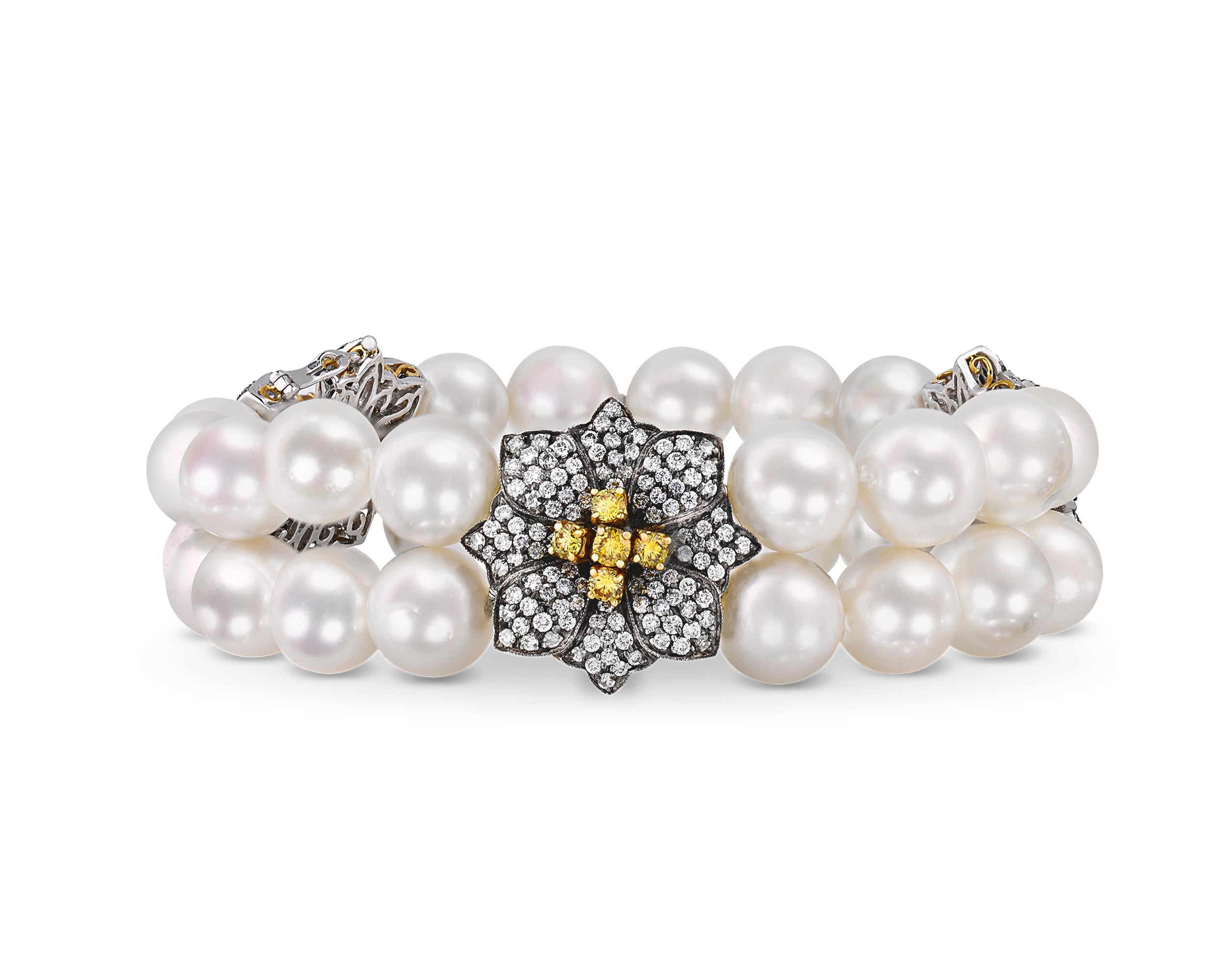 Two strands of South Sea pearls comprise this elegant bracelet, and the gems exhibit the perfect hue and luster for which pearls from the South Sea are renowned. Florets featuring vibrant yellow diamonds totaling 1.11 carats and white diamonds
