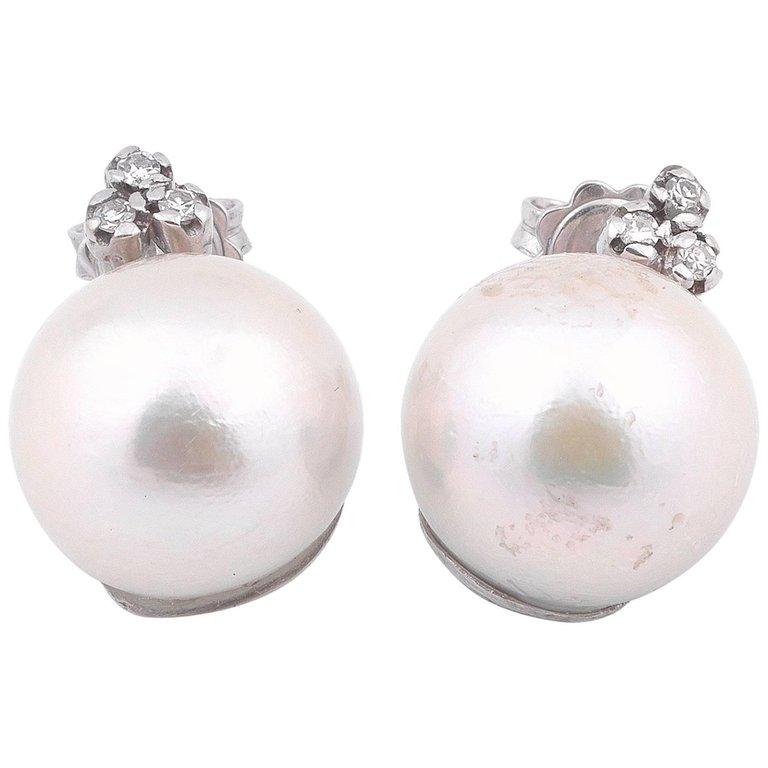 
A south sea pearl and diamond earrings, the pearl measuring approximately 14mm, with a three diamond, mounted in white gold.
Closure: Push Post  