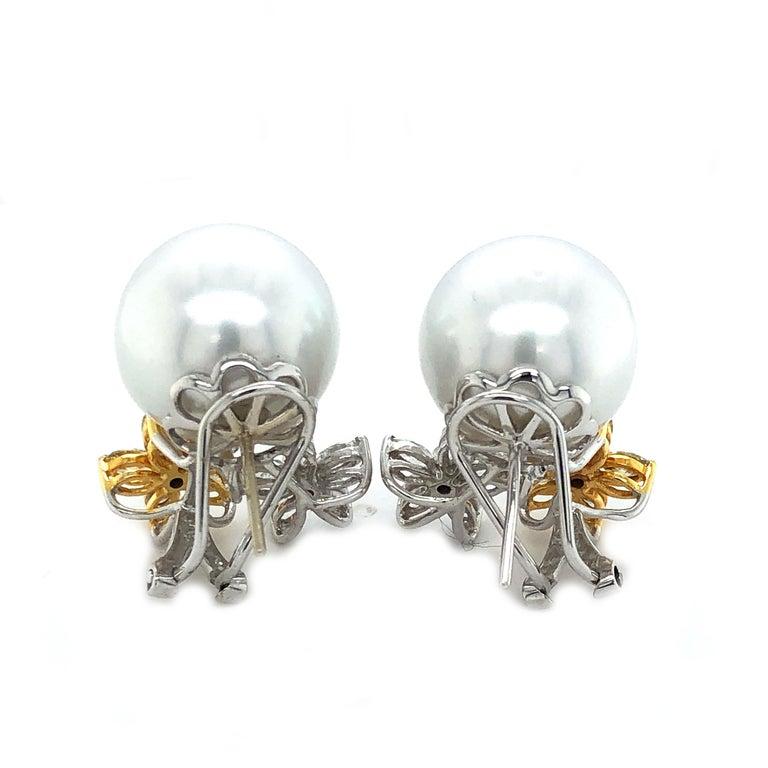 Beautiful South Sea pearl and diamond earrings. These earrings have 16.7-17mm South Sea pearls with fancy yellow and white diamond accents set in 18k white and yellow gold.