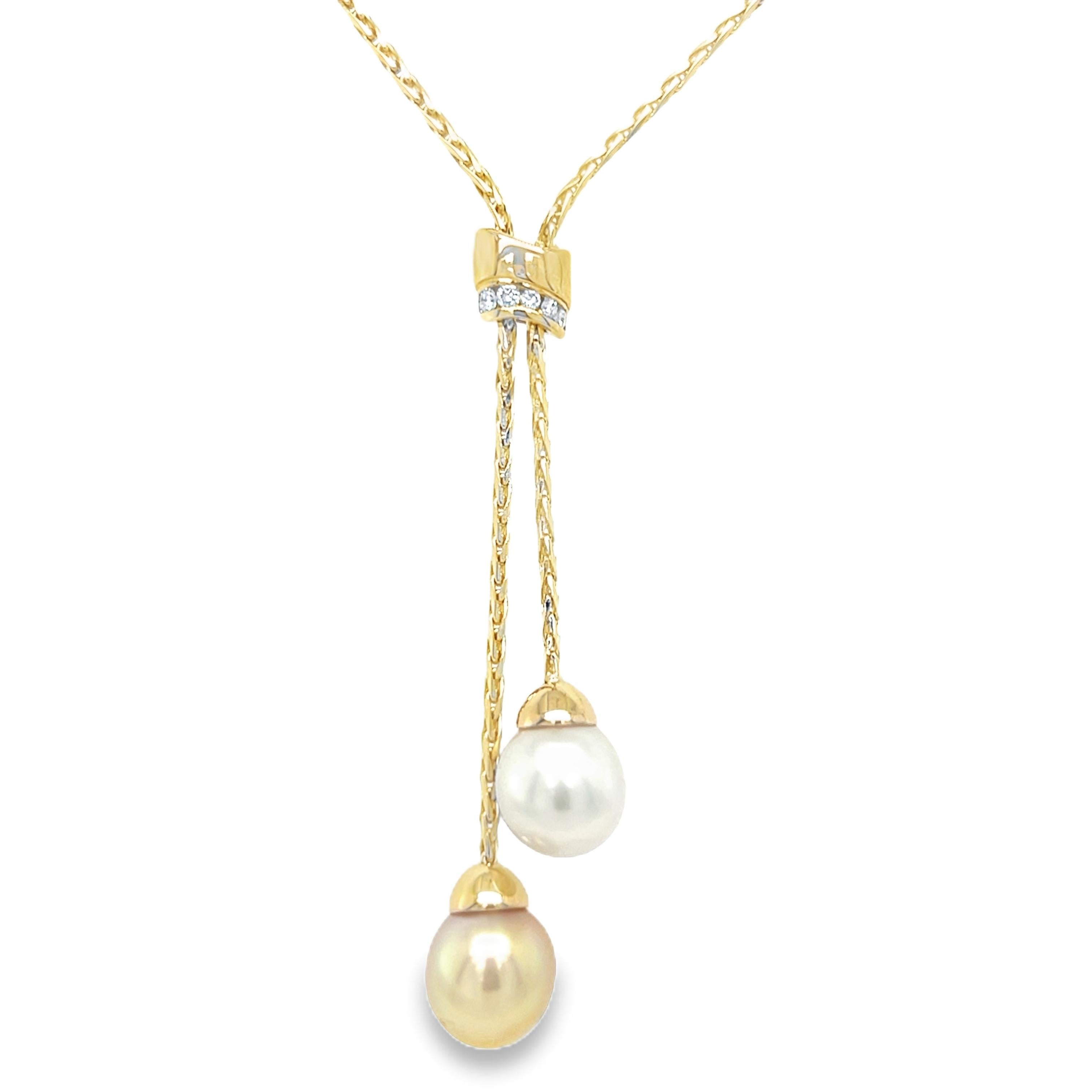 14 karat yellow gold lariat necklace featuring one 11mm white South Sea cultured pearl  and one 11mm Golden South Sea cultured pearl accented by 7 round brilliant cut diamonds of VS clarity and H color totaling approximately 0.25 carats. 20 inch