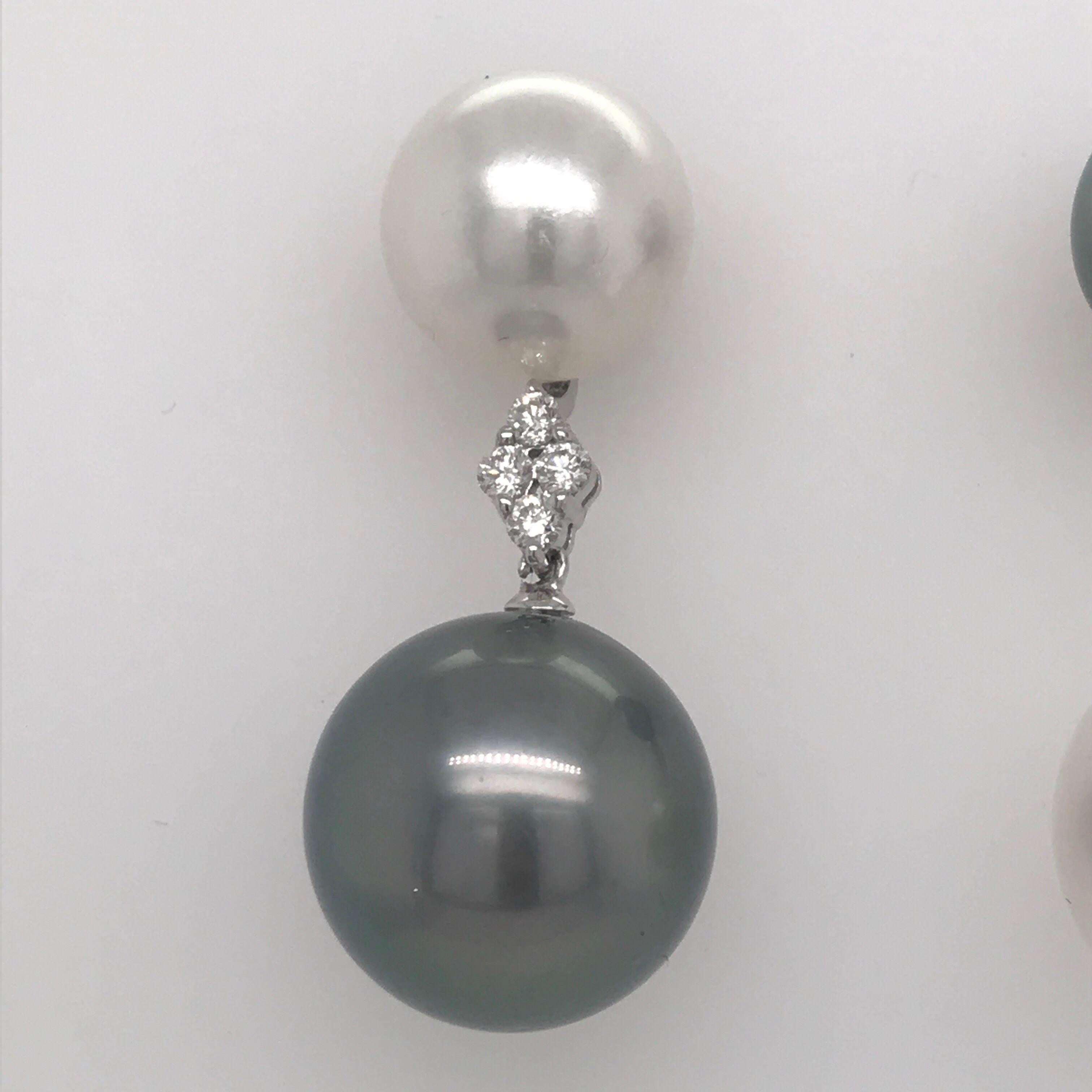 18K White gold drop earrings featuring alternating white South Sea pearls and grey tone Tahitian pearl with 4 round brilliants weighing 0.32 carats. 
Color G-H
Clarity SI
Pearls measure 12-14 mm
