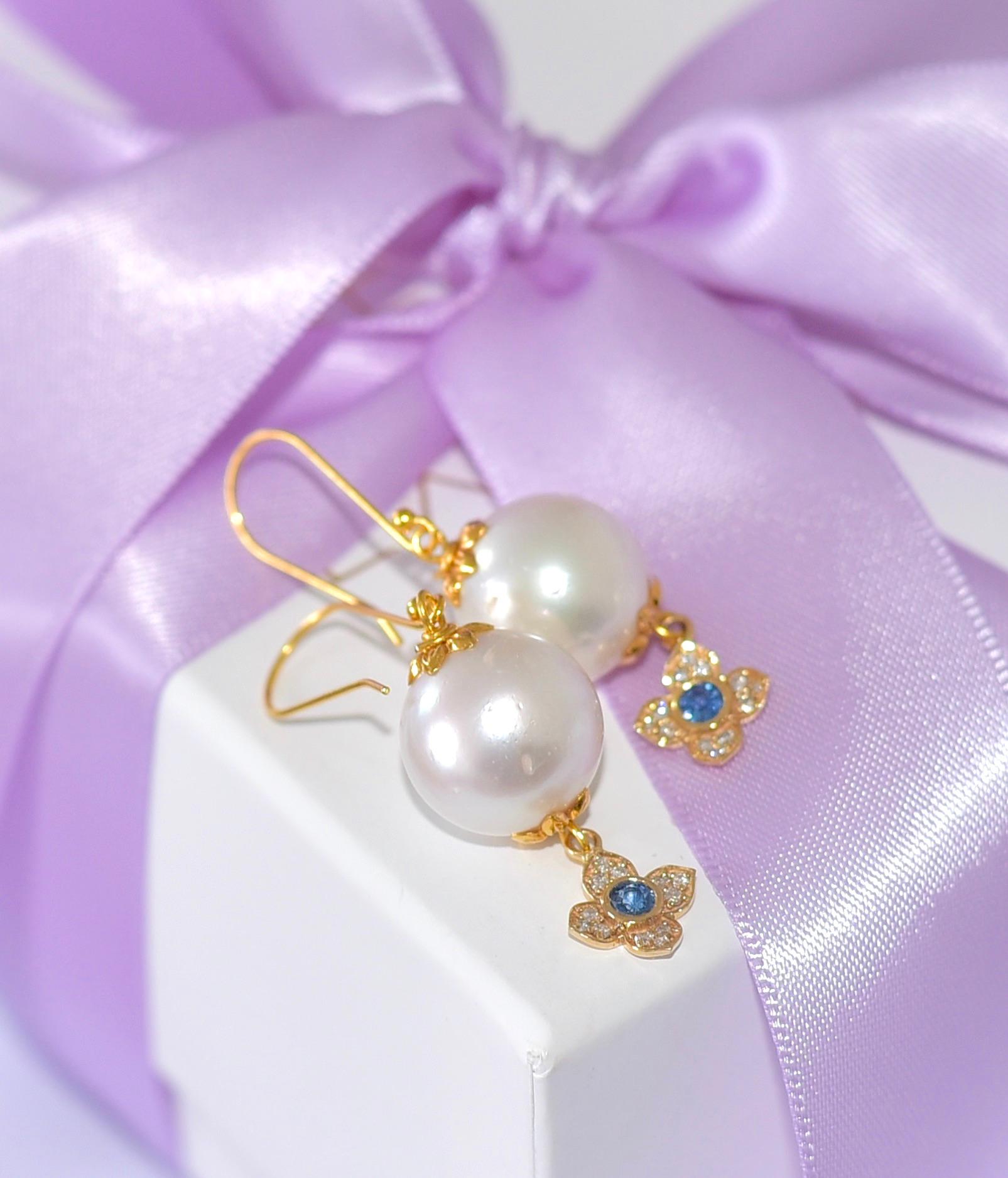 Beautiful, dangling, vivacious, outstanding Artisan style elegant pearl earrings!
These earrings are real eye-catchers! Long, large White South Sea Pearls ( 13.5mm ) and a wonderful flower with a Natural Blue Sapphire ​​give the earring a feminine