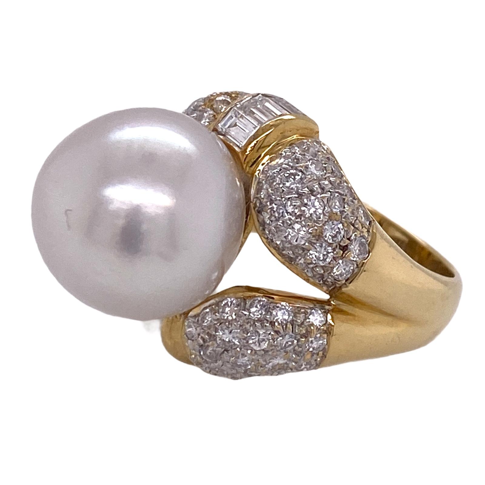 Stunning South Sea pearl and diamond ring fashioned in 18 karat yellow gold. The 14.2mm white South Sea pearl is set into a mounting featuring 90 round and baguette shape diamonds weighing approximately 2.00 carat total weight. The diamonds are