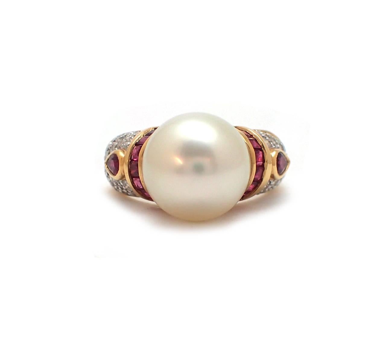 This breathtaking ring prominently features an 11mm pearl flanked by pear and square cut rubies totaling approximately .80ct, and .30ct of round diamonds. Set in 18kt yellow gold, this piece can be dressed up or down.  Diamonds are G-H color, SI1