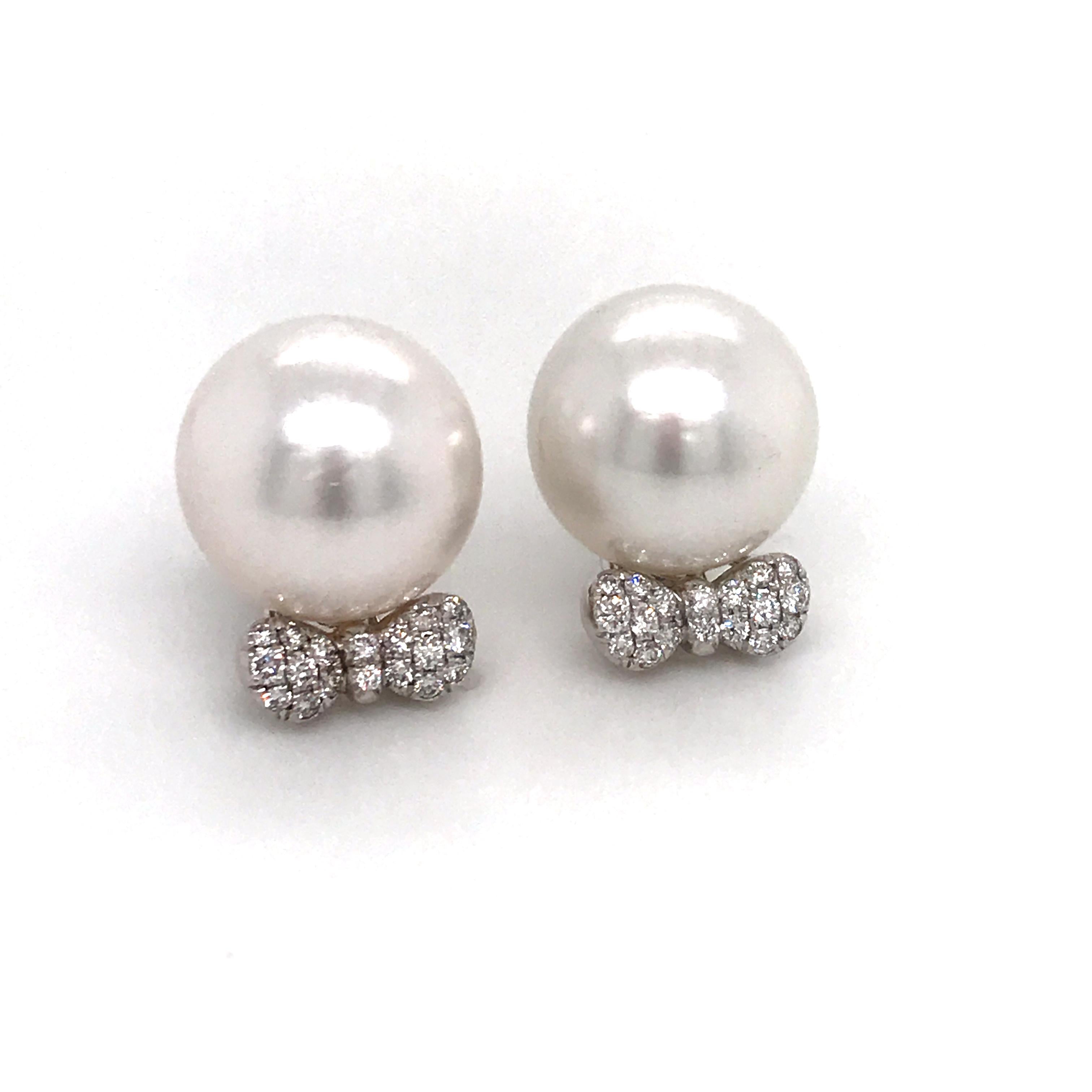 18K White gold earrings featuring two South Sea Pearls measuring 13-14 mm with a diamond motif bow with 36 diamonds weighing 0.36 carats. 
Color G-H
Clarity SI

Bow measures 7/16