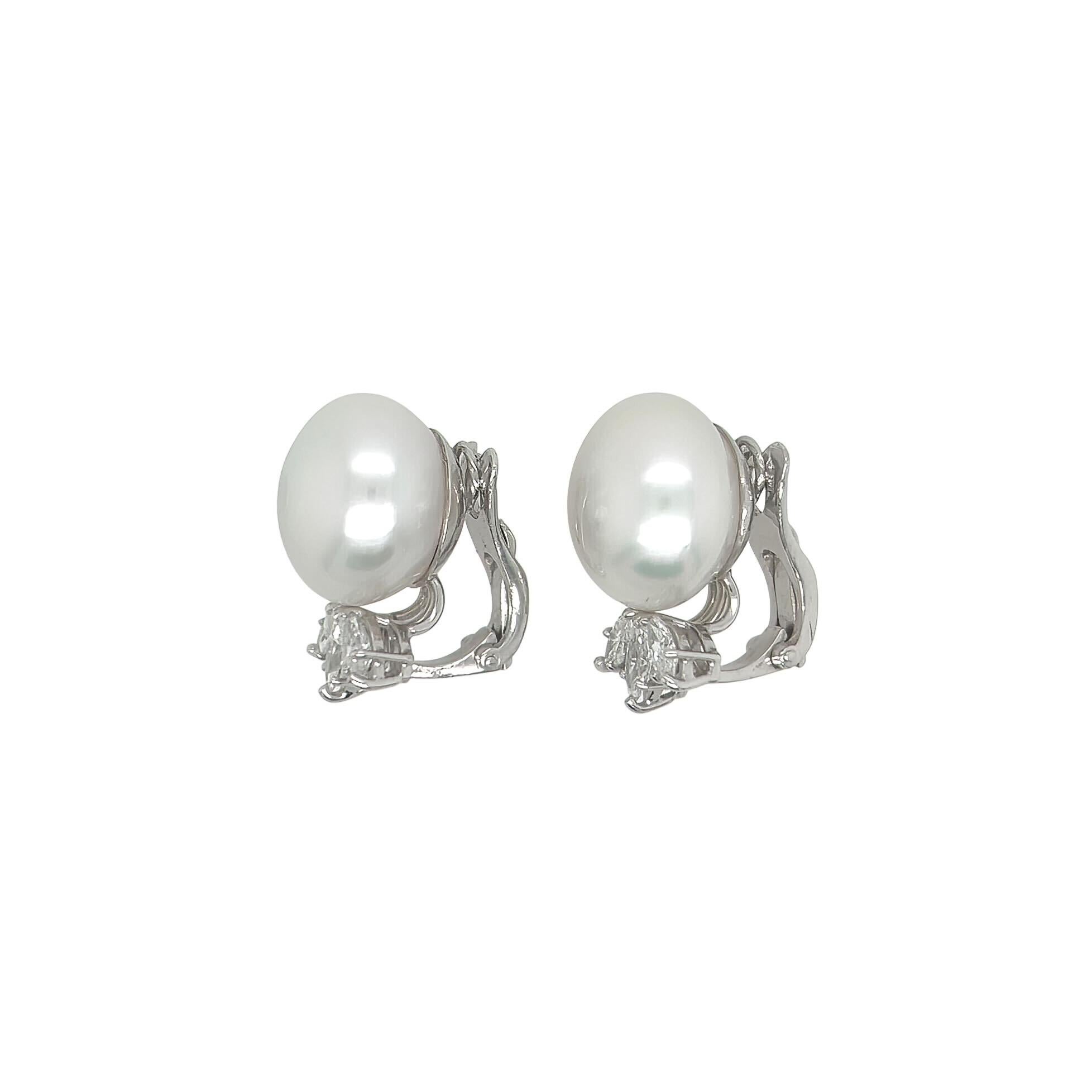 A pair of platinum, pearl and diamond earclips.  Each earclip designed as a South Sea button pearl measuring approximately 15.5 mm above a triad of marquise cut diamonds, with 18 karat white gold clips.  Total diamond weight approximately 2.10