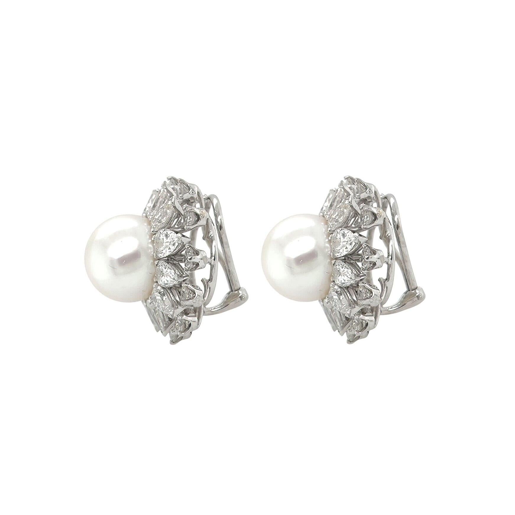 A pair of 18 karat white gold, pearl and diamond earclips.  Each earclip centering a South Sea pearl measuring approximately 13.5 mm surrounded by 12 pear shaped diamonds, further surrounded by 12 round brilliant cut diamonds.  Total diamond weight