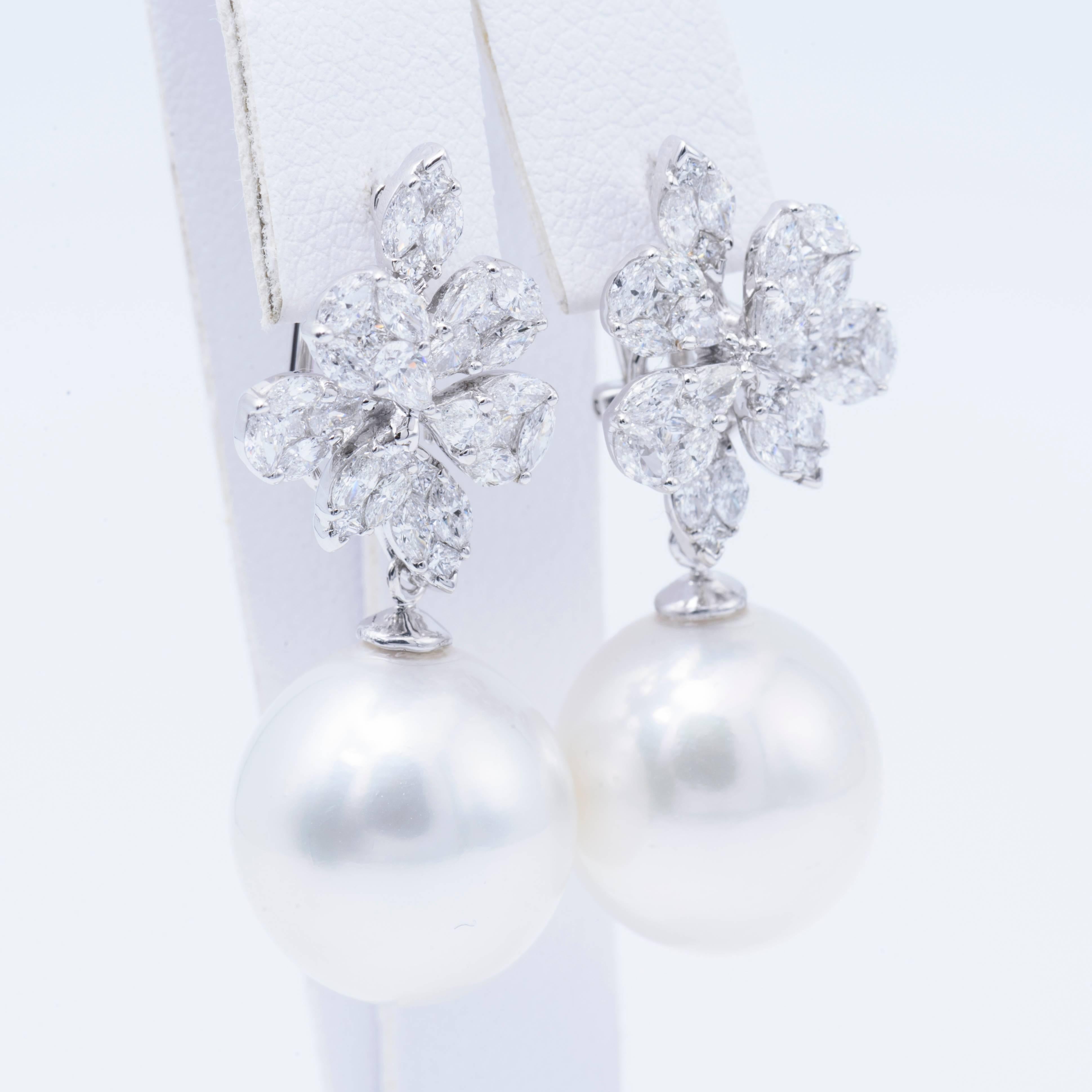 18K White gold earrings featuring two South Sea Pearl measuring 14-15 mm with a diamond cluster top of marquise, pear, princess and round brilliants weighing 2.14 carats.  
Color: H
Clarity: VS 
