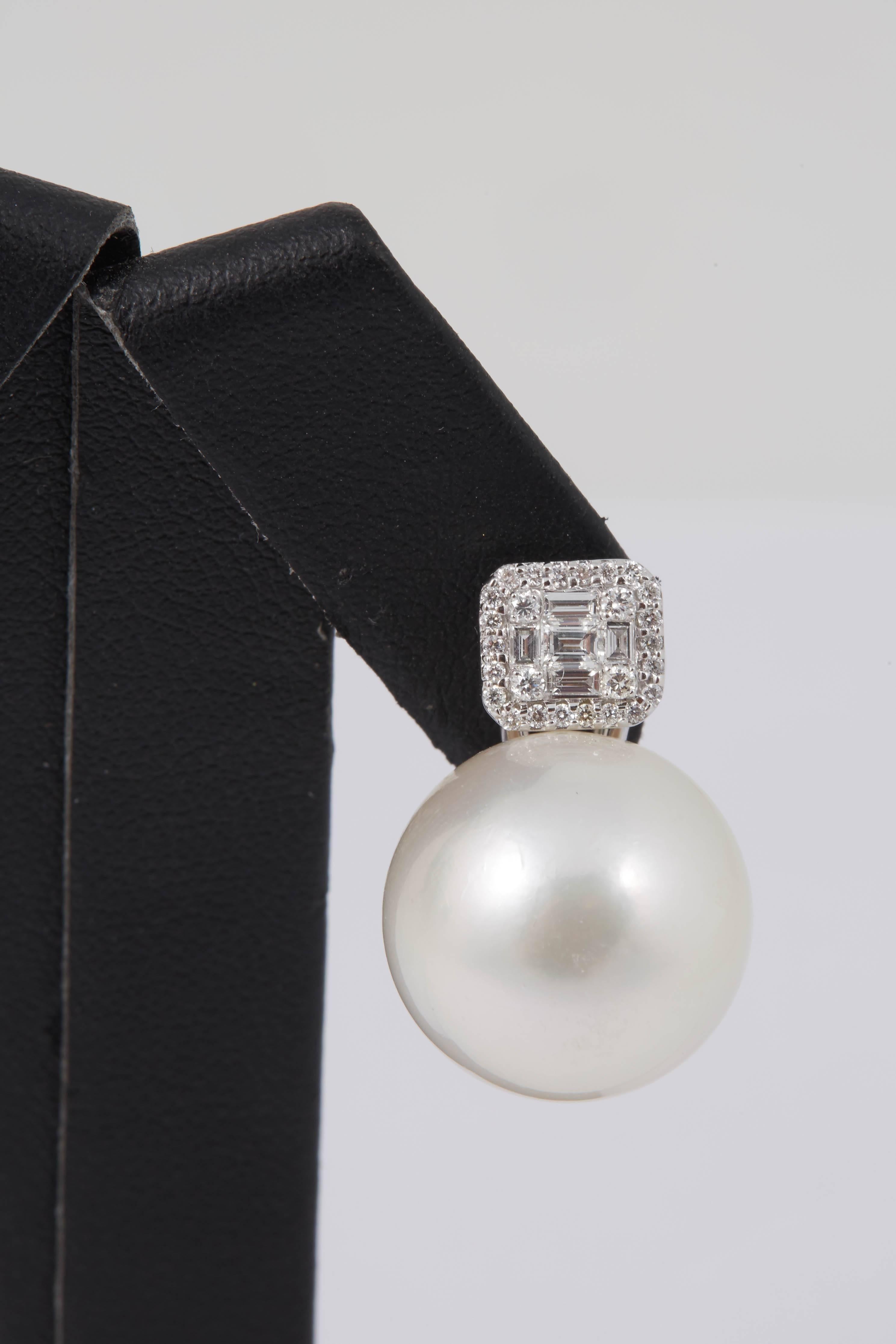 boucles d'oreilles pendantes en or blanc 18 carats présentant deux perles des mers du Sud mesurant 15-16 MM flanquées de 10 diamants baguette pesant 0.30 carats et 52 brillants ronds pesant 0.30 carats.
